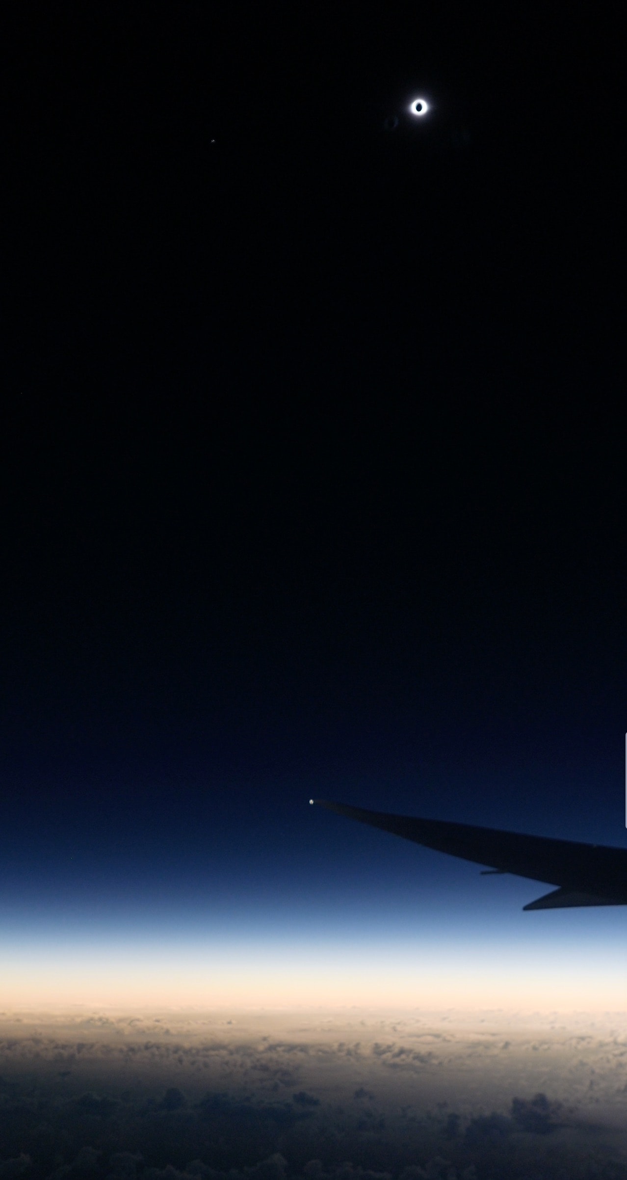 The total phase of the July 2nd solar eclipse lasted about 4 minutes and 30 seconds at the point of maximum eclipse. On the surface of planet Earth, that was about 600 nautical miles north of Easter Island in the Southern Pacific Ocean. But from 41,000 feet above, on a charter flight intercepting the Moon's shadow, the Moon could be seen to completely block the Sun for about 8 minutes and 30 seconds. With a tailwind at the mid-eclipse intercept point, the plane was traveling around 488 nautical miles per hour chasing along the Moon's shadow track. From above the clouds this wide-field image of the totally eclipsed Sun and shimmering solar corona over the wing records the spectacular view from a window seat on the sunward side of the aircraft.