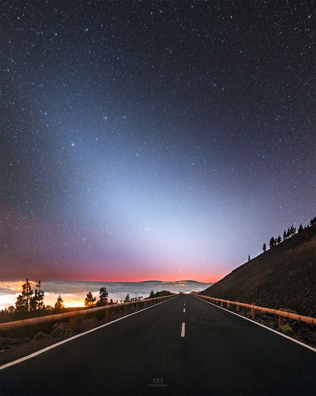What's that strange light down the road? Dust orbiting the Sun. At certain times of the year, a band of sun-reflecting dust from the inner Solar System appears prominently just after sunset -- or just before sunrise -- and is called zodiacal light.  Although the origin of this dust is still being researched, a leading hypothesis holds that zodiacal dust originates mostly from faint Jupiter-family comets and slowly spirals into the Sun. Recent analysis of dust emitted by Comet 67P, visited by ESA's robotic Rosetta spacecraft, bolster this hypothesis.  Pictured when climbing a road up to Teide National Park in the Canary Islands of Spain, a bright triangle of zodiacal light appeared in the distance soon after sunset. Captured on June 21, the scene includes bright Regulus, alpha star of Leo, standing above center toward the left. The Beehive Star Cluster (M44) can be spotted below center, closer to the horizon and also immersed in the zodiacal glow.