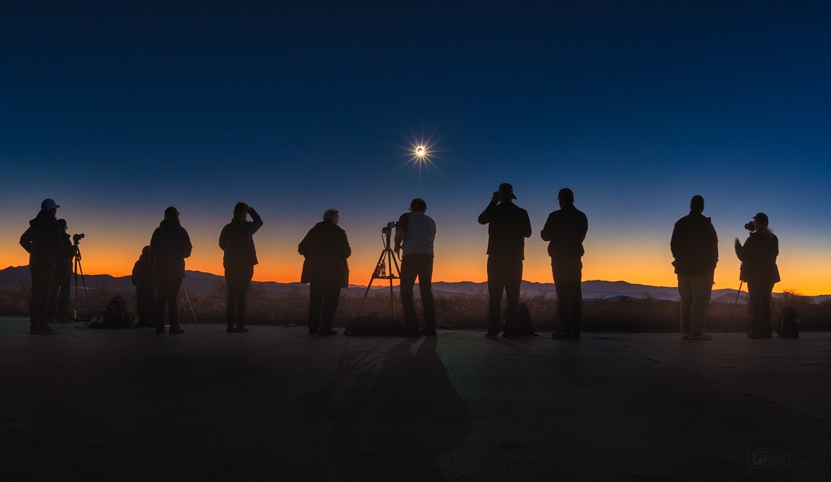 On July 2 denizens of planet Earth could stand in the Moon's dark umbral shadow during South America's 2019 total solar eclipse. It first touched down in the Southern Pacific Ocean, east of New Zealand. Racing toward the east along a narrow track, the shadow of the Moon made landfall along the Chilean coast with the Sun low on the western horizon. Captured in the foreground here are long shadows still cast by direct sunlight though, in the final moments before totality began. While diffraction spikes are from the camera lens aperture, the almost totally eclipsed Sun briefly shone like a beautiful diamond ring in the clear, darkened sky.