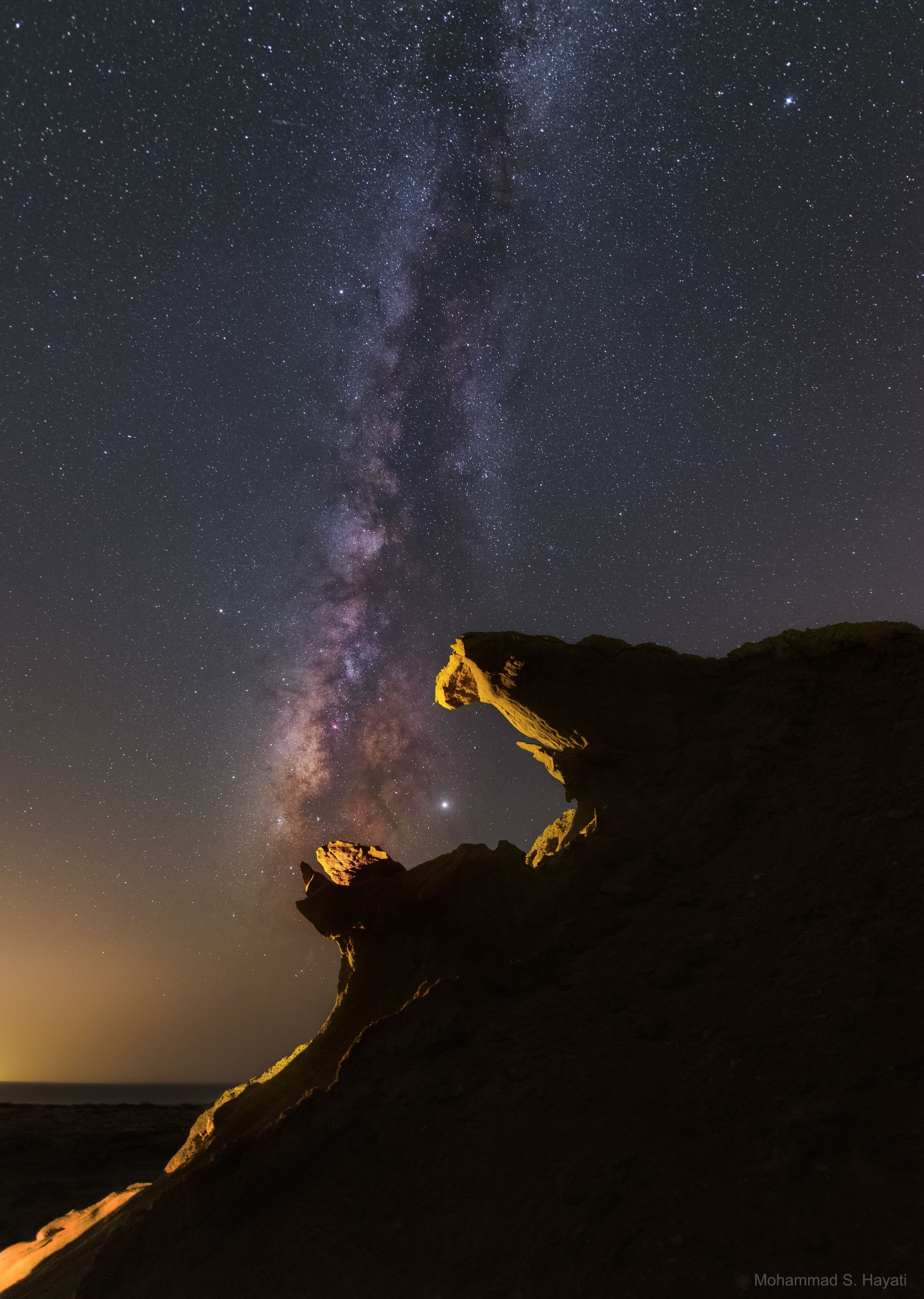 This is a good month to see Jupiter. To find our Solar System's largest planet in your sky, look toward the southeast just after sunset -- Jupiter should be the brightest object in that part of the sky.  If you have a binoculars or a small telescope, you should be able to see Jupiter's four brightest moons right nearby, and possibly some cloud bands. The featured image was taken about a month ago from the Persian Gulf. The image shows Jupiter just to the right of the nearly vertical band of the central disk of our Milky Way Galaxy.  The unnamed rock formations appear in projection like the jaws of a giant monster ready to engulf the Jovian giant.  When you see Jupiter, it may be interesting to know that NASA's robotic Juno spacecraft is simultaneously visiting and studying the giant planet.  Saturn is also visible this month, and although it is nearby to Jupiter, it is not as bright.