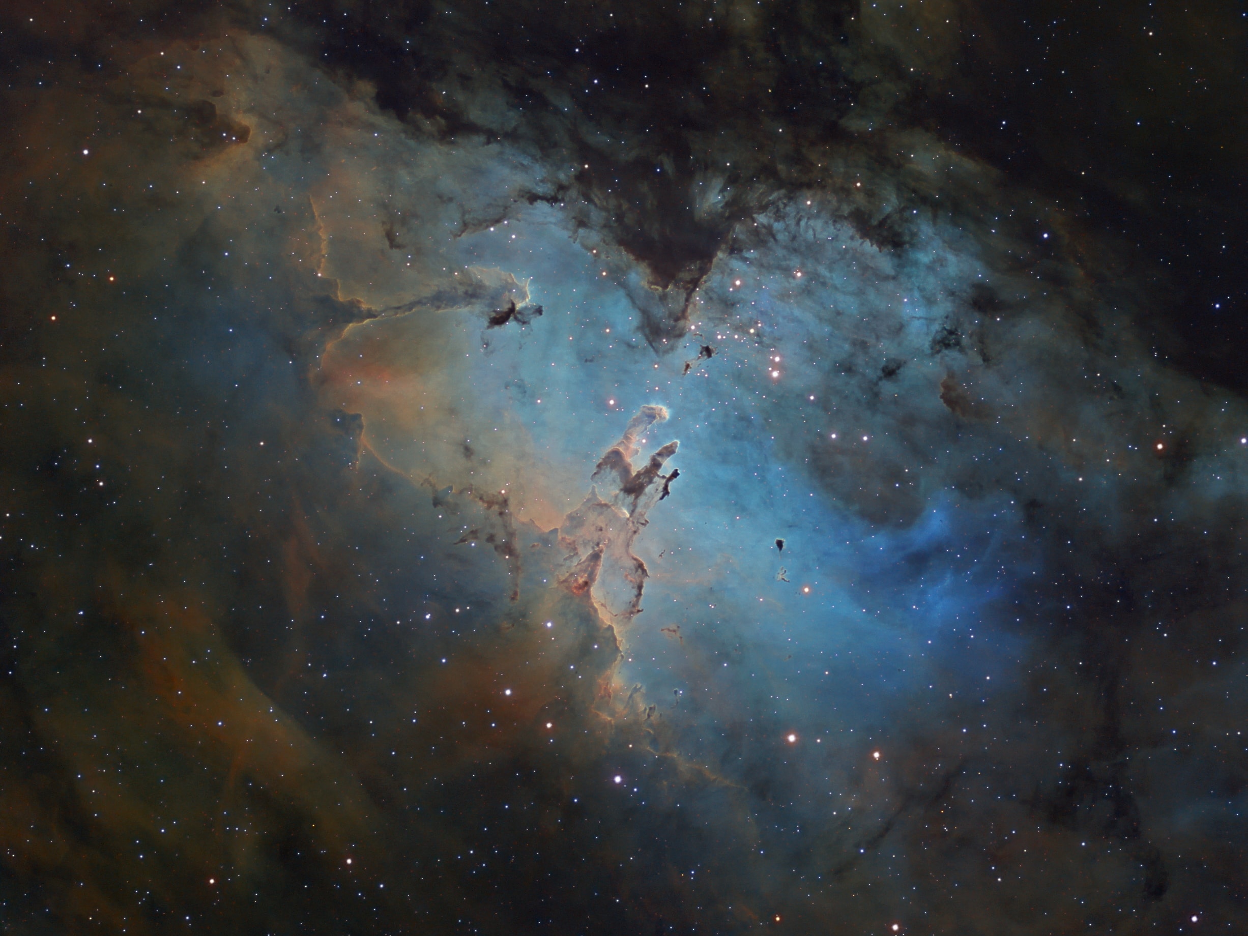 A star cluster around 2 million years young surrounded by natal clouds of dust and glowing gas, M16 is also known as The Eagle Nebula. This beautifully detailed image of the region adopts the colorful Hubble palette and includes cosmic sculptures made famous in Hubble Space Telescope close-ups of the starforming complex. Described as elephant trunks or Pillars of Creation, dense, dusty columns rising near the center are light-years in length but are gravitationally contracting to form stars. Energetic radiation from the cluster stars erodes material near the tips, eventually exposing the embedded new stars. Extending from the ridge of bright emission left of center is another dusty starforming column known as the Fairy of Eagle Nebula. M16 lies about 7,000 light-years away, an easy target for binoculars or small telescopes in a nebula rich part of the sky toward the split constellation Serpens Cauda (the tail of the snake).   Watch: Perseid Meteor Shower