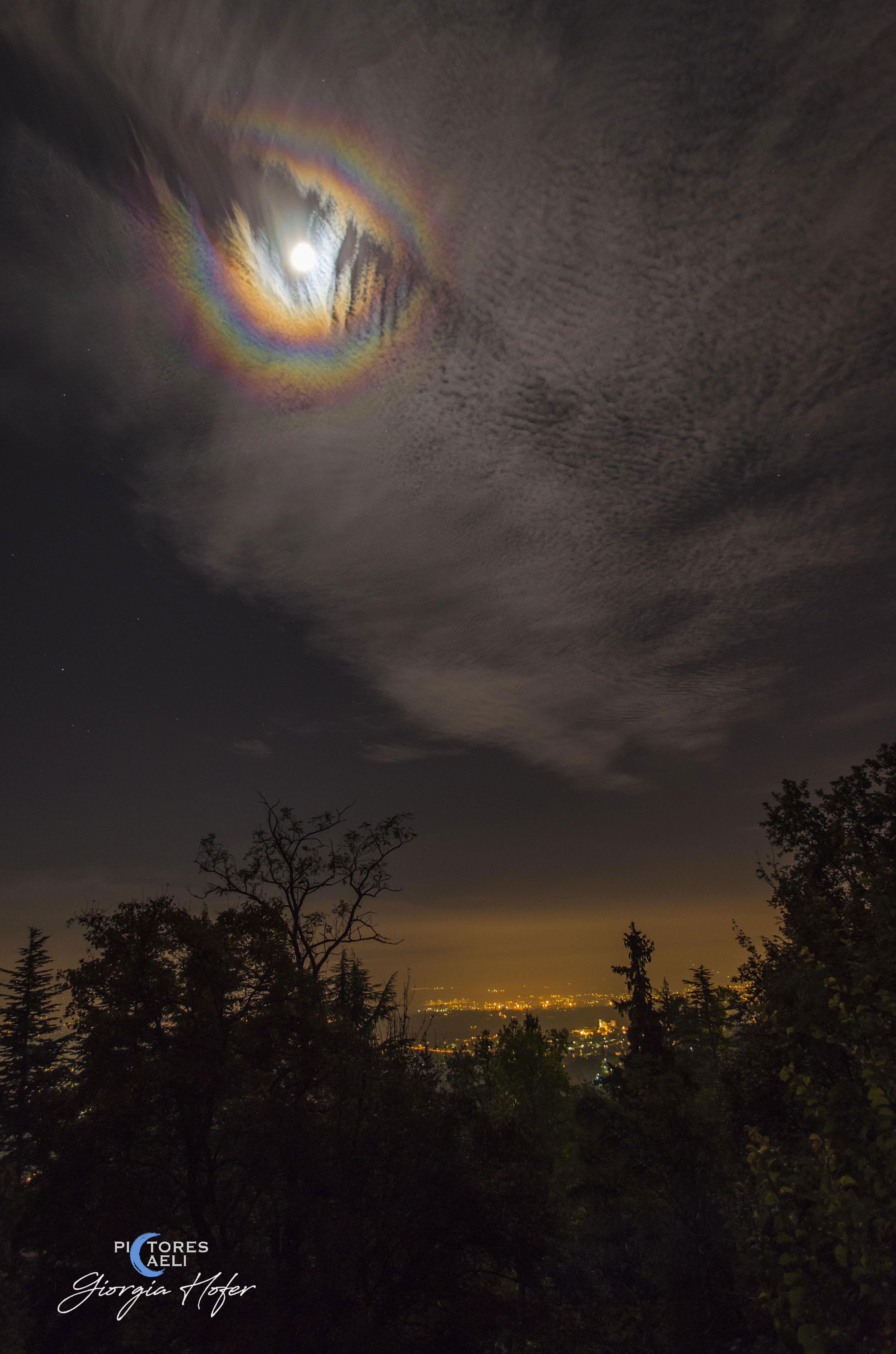 What are those colorful rings around the Moon? A corona. Rings like this will sometimes appear when the Moon is seen through thin clouds. The effect is created by the quantum mechanical diffraction of light around individual, similarly-sized water droplets in an intervening but mostly-transparent cloud. Since light of different colors has different wavelengths, each color diffracts differently. Lunar Coronae are one of the few  quantum mechanical color effects that can be easily seen with the unaided eye.  The featured lunar corona was captured around full Moon above Turin, Italy in 2014.  Similar coronae that form around the Sun are usually harder to see because of the Sun's great brightness.