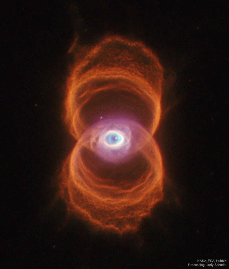 Do you see the hourglass shape -- or does it see you?  If you can picture it, the rings of MyCn 18 trace the outline of an hourglass -- although one with an unusual eye in its center.  Either way, the sands of time are running out for the central star of this hourglass-shaped planetary nebula. With its nuclear fuel exhausted, this brief, spectacular, closing phase of a Sun-like star's life occurs as its outer layers are ejected - its core becoming a cooling, fading white dwarf. In 1995, astronomers used the Hubble Space Telescope (HST) to make a series of images of planetary nebulae, including the one featured here.  Pictured, delicate rings of colorful glowing gas (nitrogen-red, hydrogen-green, and oxygen-blue) outline the tenuous walls of the hourglass. The unprecedented sharpness of the Hubble images has revealed surprising details of the nebula ejection process that are helping to resolve the outstanding mysteries of the complex shapes and symmetries of planetary nebulas like MyCn 18.