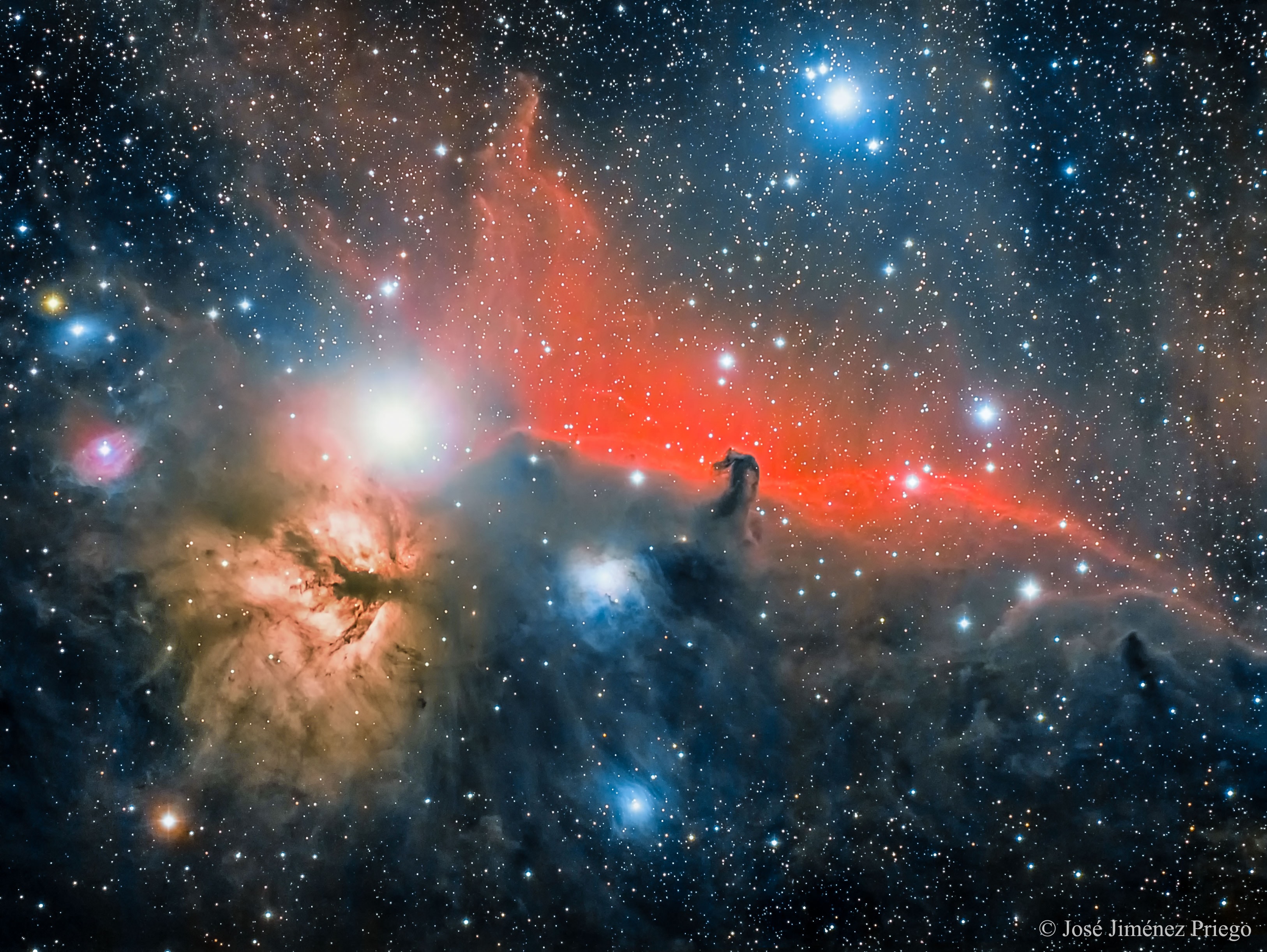 The Horsehead Nebula is one of the most famous nebulae on the sky.  It is visible as the dark indentation to the red emission nebula in the center of the above photograph.  The horse-head feature is dark because it is really an opaque dust cloud that lies in front of the bright red emission nebula. Like clouds in Earth's atmosphere, this cosmic cloud has assumed a recognizable shape by chance.  After many thousands of years, the internal motions of the cloud will surely alter its appearance.  The emission nebula's red color is caused by electrons recombining with protons to form hydrogen atoms.  On the image left is the Flame Nebula, an orange-tinged nebula that also contains filaments of dark dust. Just to the lower left of the Horsehead nebula featured picture is a blueish reflection nebulae that preferentially reflects the blue light from nearby stars.