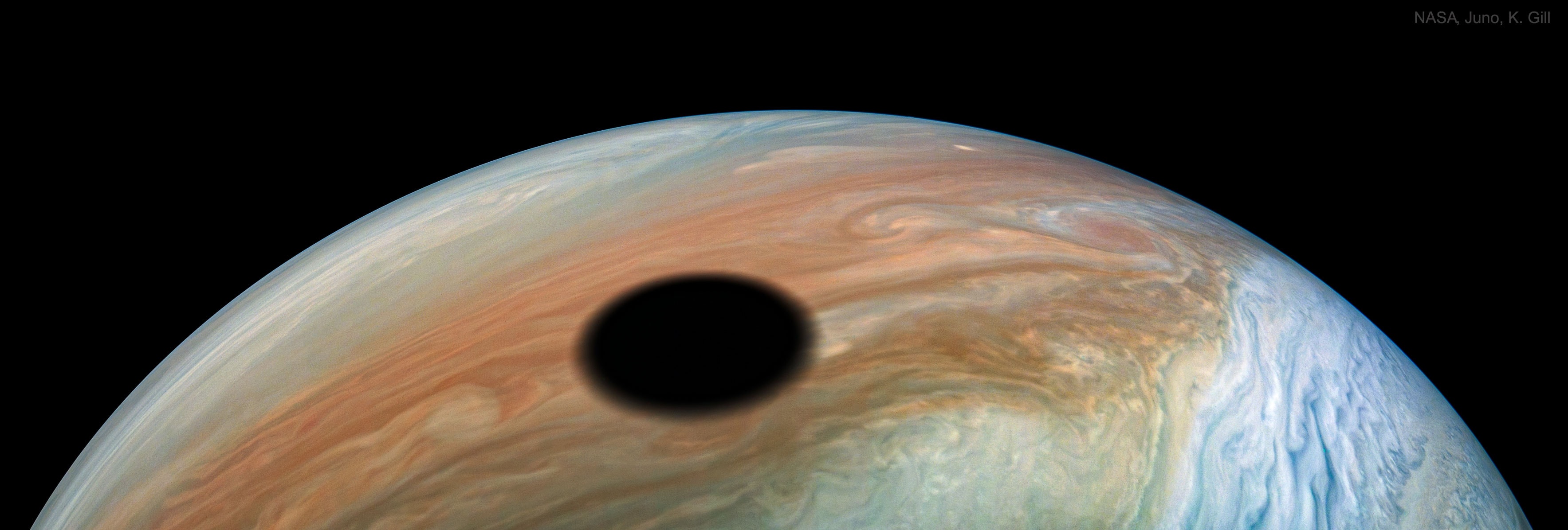 What's that dark spot on Jupiter? It's the shadow of Jupiter's most volcanic moon Io. Since Jupiter shines predominantly by reflected sunlight, anything that blocks that light leaves a shadow.  If you could somehow be in that shadow, you would see a total eclipse of the Sun by Io.  Io's shadow is about 3600 kilometers across, roughly the same size as Io itself -- and only slightly larger than Earth's Moon. The featured image was taken last month by NASA's robotic Juno spacecraft currently orbiting Jupiter. About every two months, Juno swoops close by Jupiter, takes a lot of data and snaps a series of images -- some of which are made into a video. Among many other things, Juno has been measuring Jupiter's gravitational field, finding surprising evidence that Jupiter may be mostly a liquid. Under unexpectedly thick clouds, the Jovian giant may house a massive liquid hydrogen region that extends all the way to the center.