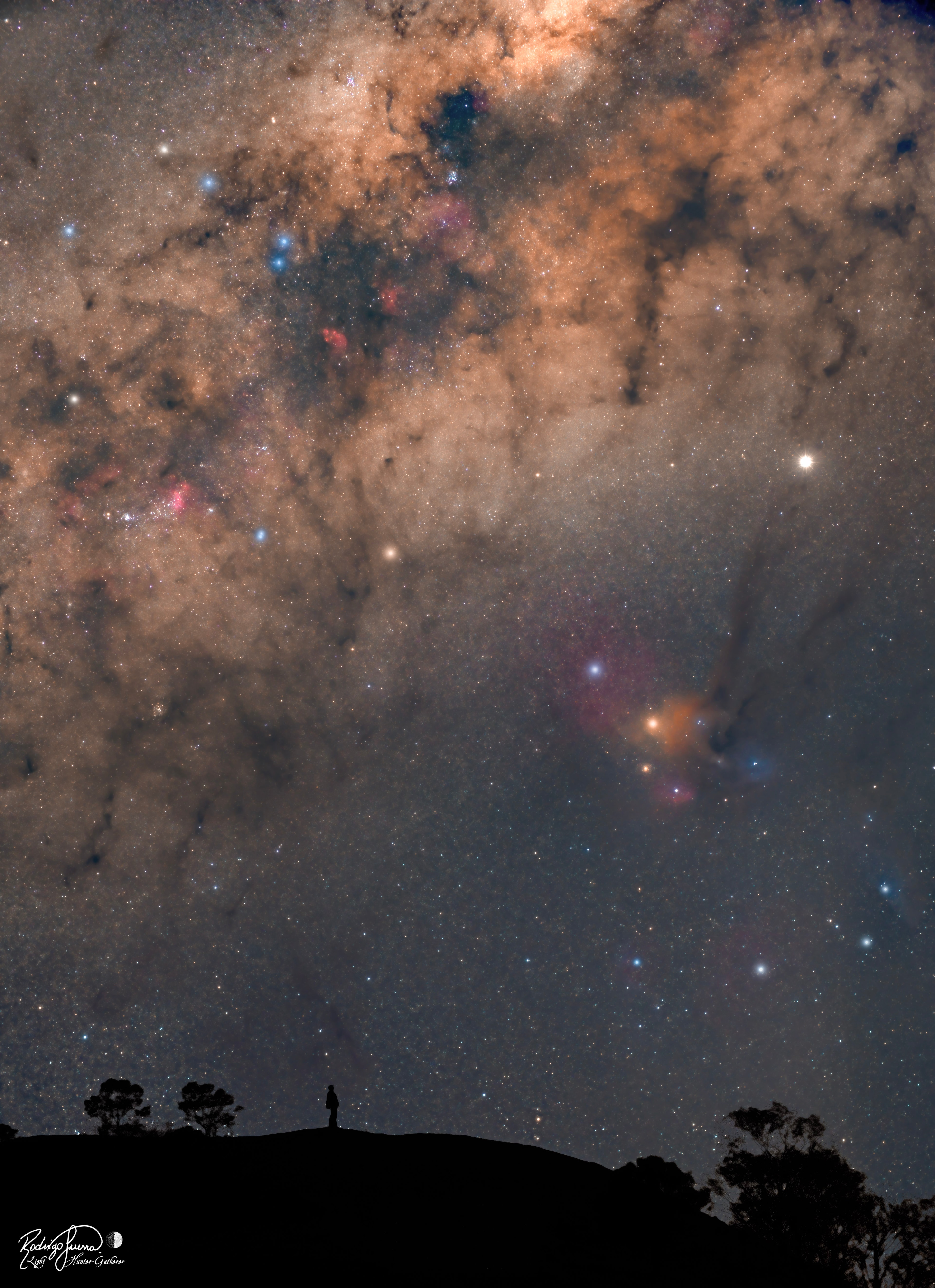 Have you contemplated your home galaxy lately?  If your sky looked like this, perhaps you'd contemplate it more often! The featured picture is actually a composite of two images taken last month from the same location in south Brazil and with the same camera -- but a few hours apart.  The person in the image -- also the astrophotographer -- has much to see in the Milky Way Galaxy above. The central band of our home Galaxy stretches diagonally up from the lower left. This band is dotted with spectacular sights including dark nebular filaments, bright blue stars, and red nebulas.  Millions of fainter and redder stars fill in the deep Galactic background.  To the lower right of the Milky Way are the colorful gas and dust clouds of Rho Ophiuchi, featuring the bright orange star Antares.  On this night, just above and to the right of Antares was the bright planet Jupiter.  The sky is so old and so familiar that humanity has formulated many stories about it, some of which inspired this very picture.