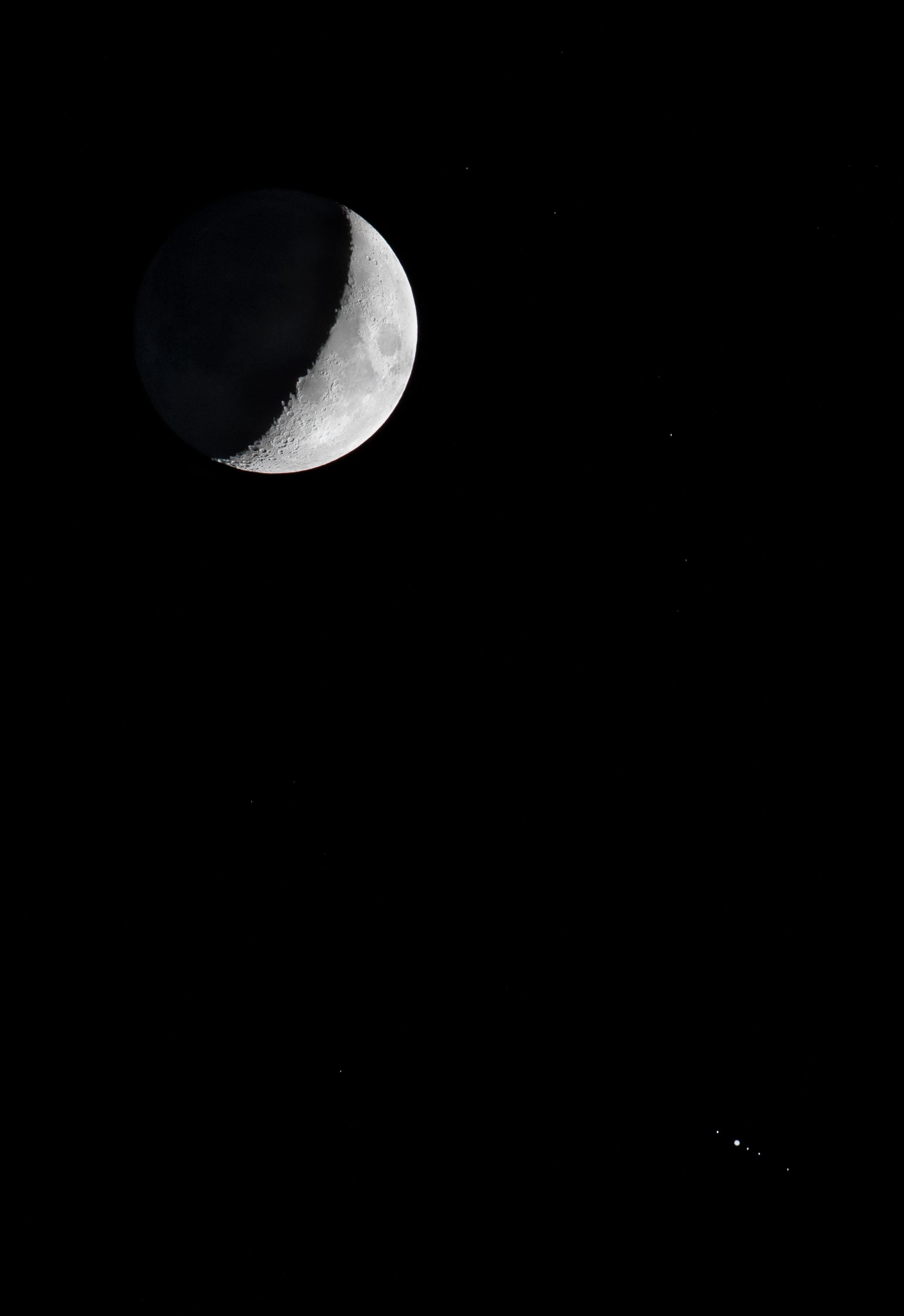 After sunset on October 3, some of the Solar System's largest moons stood low along the western horizon with the largest planet. Just after nightfall, a pairing of the Moon approaching first quarter phase and Jupiter was captured in this telephoto field of view. A blend of short and long exposures, it reveals the familiar face of our fair planet's own large natural satellite in stark sunlight and faint earthshine. At lower right are the ruling gas giant and its four Galilean moons. Left to right, the tiny pinpricks of light are Ganymede, [Jupiter], Io, Europa, and Callisto. Our own natural satellite appears to loom large because it's close, but Ganymede, Io, and Callisto are actually larger than Earth's Moon. Water world Europa is only slightly smaller. Of the Solar System's six largest planetary satellites, only Saturn's moon Titan, is missing from this scene. But be sure to check for large moons in your sky tonight.   Tonight: International Observe the Moon Night  Submitted to APOD: The Moon and Jupiter with its Satellites