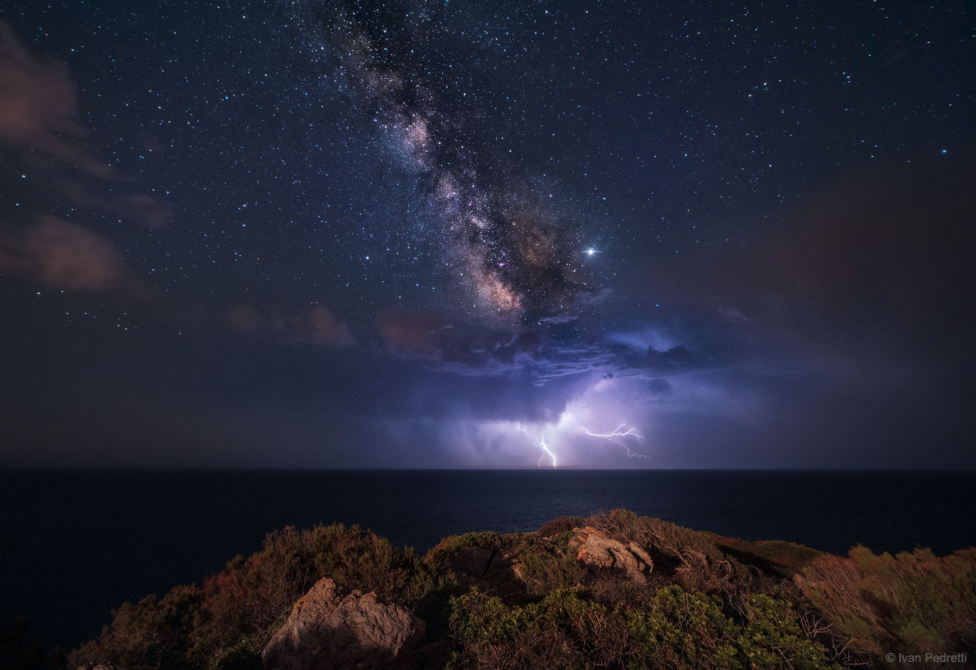 It may appear, at first, like the Galaxy is producing the lightning, but really it's the Earth. The featured nighttime landscape was taken from a southern tip of the Italian Island of Sardinia in early June. The foreground rocks and shrubs are near the famous Capo Spartivento Lighthouse, and the camera is pointed south toward Algeria in Africa.  In the distance, across the Mediterranean Sea, a thunderstorm is threatening, with several electric lightning strokes caught together during this 25-second wide-angle exposure.  Much farther in the distance, strewn about the sky, are hundreds of stars in the neighborhood of our Sun in the Milky Way Galaxy. Farthest away, and slanting down from the upper left, are billions of stars that together compose the central band of our Milky Way.   Free Lecture: APOD editor to speak in NYC on January 3