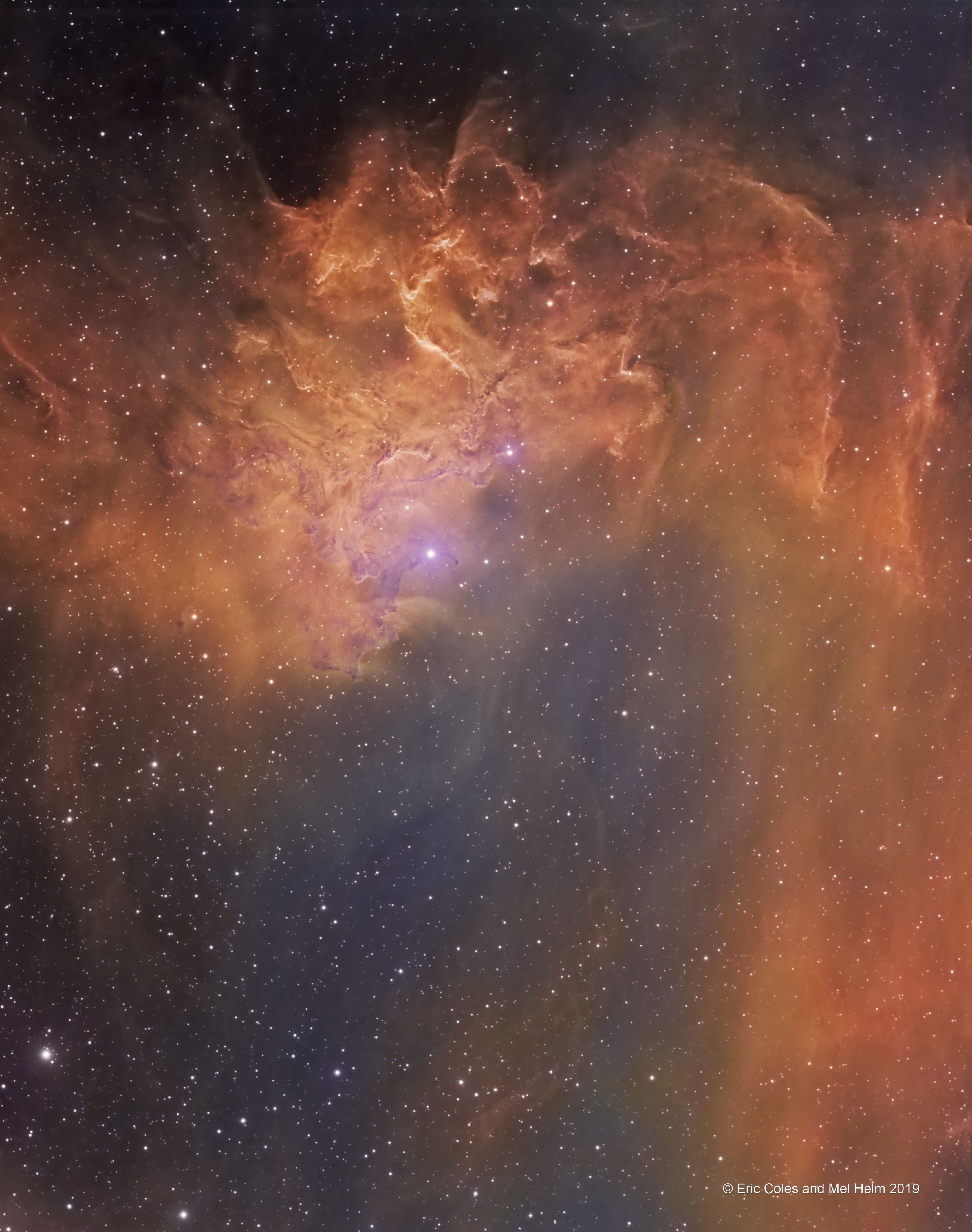 Rippling dust and gas lanes give the Flaming Star Nebula its name.  The orange and purple colors of the nebula are present in different regions and are created by different processes.  The bright star AE Aurigae, visible toward the image left, is so hot it is blue, emitting light so energetic it knocks electrons away from surrounding gas.  When a proton recaptures an electron, red light is frequently emitted (depicted here in orange). The purple region's color is a mix of this red light and blue light emitted by AE Aurigae but reflected to us by surrounding dust. The two regions are referred to as emission nebula and reflection nebula, respectively.  Pictured here in the Hubble color palette, the Flaming Star Nebula, officially known as IC 405, lies about 1500 light years distant, spans about 5 light years, and is visible with a small telescope toward the constellation of the Charioteer (Auriga).