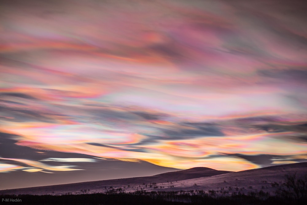 Vivid and lustrous, wafting iridescent waves of color filled this mountain and skyscape near Tanndalen, Sweden on January 3. Known as nacreous clouds or mother-of-pearl clouds, they are rare. This northern winter season they have been making unforgettable appearances at high latitudes, though. A type of polar stratospheric cloud, they form when unusually cold temperatures in the usually cloudless lower stratosphere form ice crystals. Still sunlit at altitudes of around 15 to 25 kilometers the clouds can diffract sunlight after sunset and before the dawn.