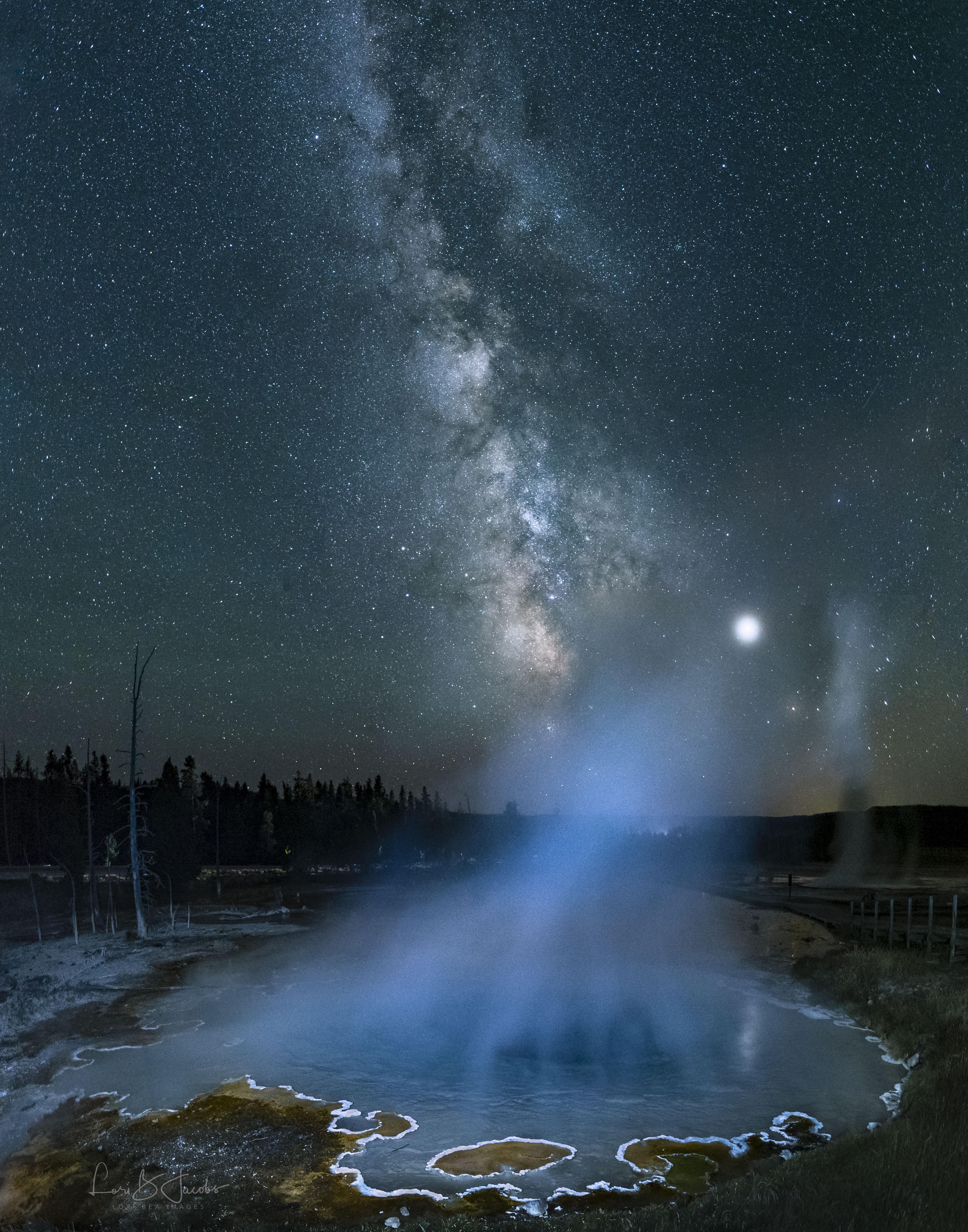 The Milky Way was not created by an evaporating lake. The pool of vivid blue water, about 10 meters across, is known as Silex Spring and is located in Yellowstone National Park in Wyoming, USA. Steam rises off the spring, heated by a magma chamber deep underneath known as the Yellowstone hotspot.  The steam blurs the image of Jupiter, making it seem unusually large.  Unrelated and far in the distance, the central band of our Milky Way Galaxy rises high overhead, a band lit by billions of stars.  The featured picture is a 3-image panorama taken last August.  If the Yellowstone hotspot causes another supervolcanic eruption as it did 640,000 years ago, a large part of North America would be affected.