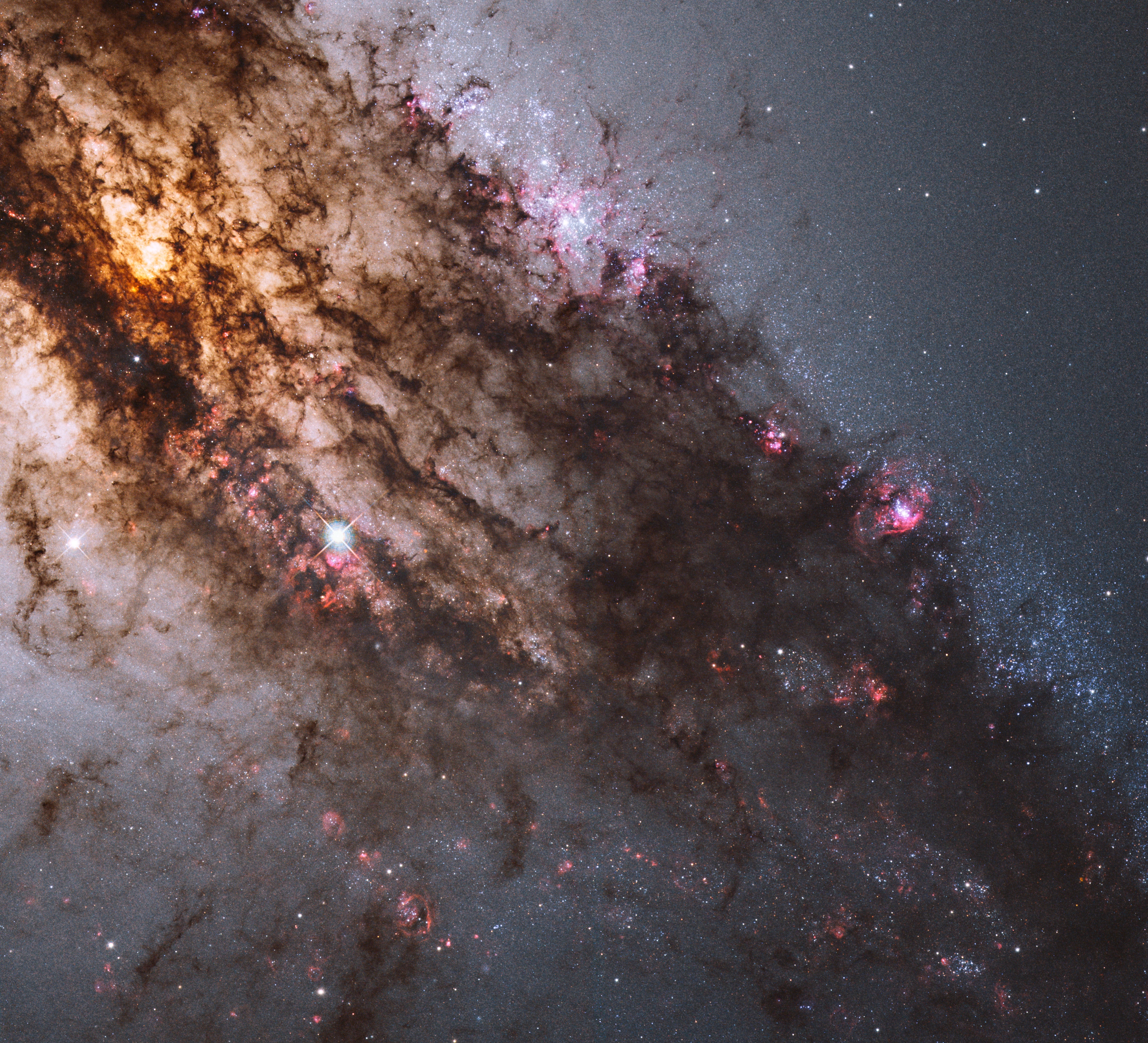 A mere 11 million light-years away, Centaurus A is the closest active galaxy to planet Earth. Also known as NGC 5128, the peculiar elliptical galaxy is over 60,000 light-years across. A region spanning about 8,500 light-years, including the galaxy's center (upper left), is framed in this sharp Hubble Space telescope close-up. Centaurus A is apparently the result of a collision of two otherwise normal galaxies resulting in a violent jumble of star forming regions, massive star clusters, and imposing dark dust lanes. Near the galaxy's center, left over cosmic debris is steadily being consumed by a central black hole with about 60 million times the mass of the Sun. As in other active galaxies, that process likely generates the radio, X-ray, and gamma-ray energy radiated by Centaurus A.