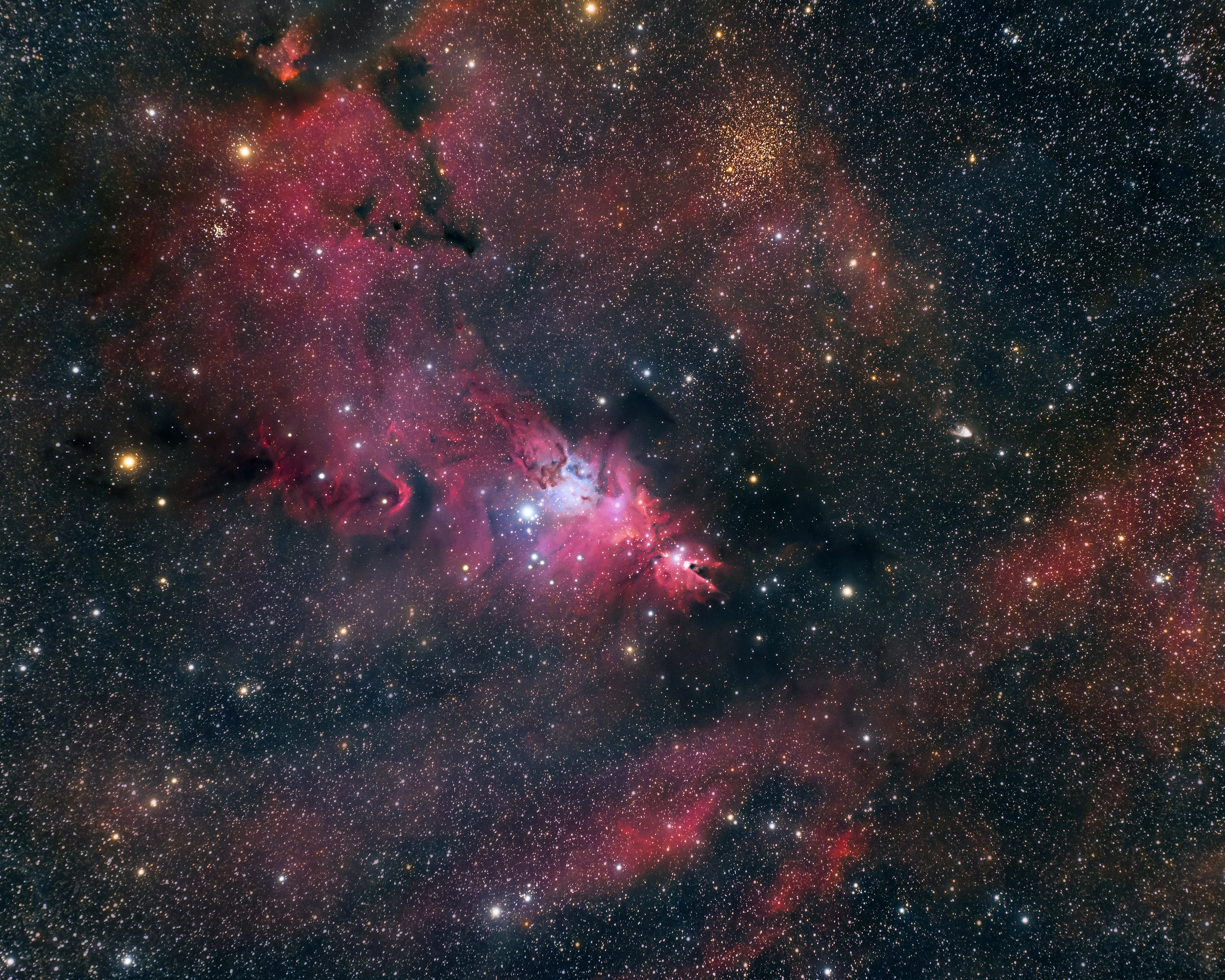 Interstellar clouds of hydrogen gas and dust abound in this gorgeous skyscape. The 3 degree wide field of view stretches through the faint but fanciful constellation Monoceros, the Unicorn. A star forming region cataloged as NGC 2264 is centered, a complex jumble of cosmic gas, dust and stars about 2,700 light-years distant. It mixes reddish emission nebulae excited by energetic light from newborn stars with dark dust clouds. Where the otherwise obscuring dust clouds lie close to hot, young stars they also reflect starlight, forming blue reflection nebulae. A few light-years across, a simple sculpted shape known as the Cone Nebula is near center. Outlined by the red glow of hydrogen gas, the cone points toward the left and bright, blue-white S Monocerotis. Itself a multiple system of massive, hot stars S Mon is adjacent to bluish reflection nebulae and the convoluted Fox Fur nebula. Expansive dark markings on the sky are silhouetted by a larger region of fainter emission with yellowish open star cluster Trumpler 5 near the top of the frame. The curious compact cometary shape right of center is known as Hubble's Variable Nebula.