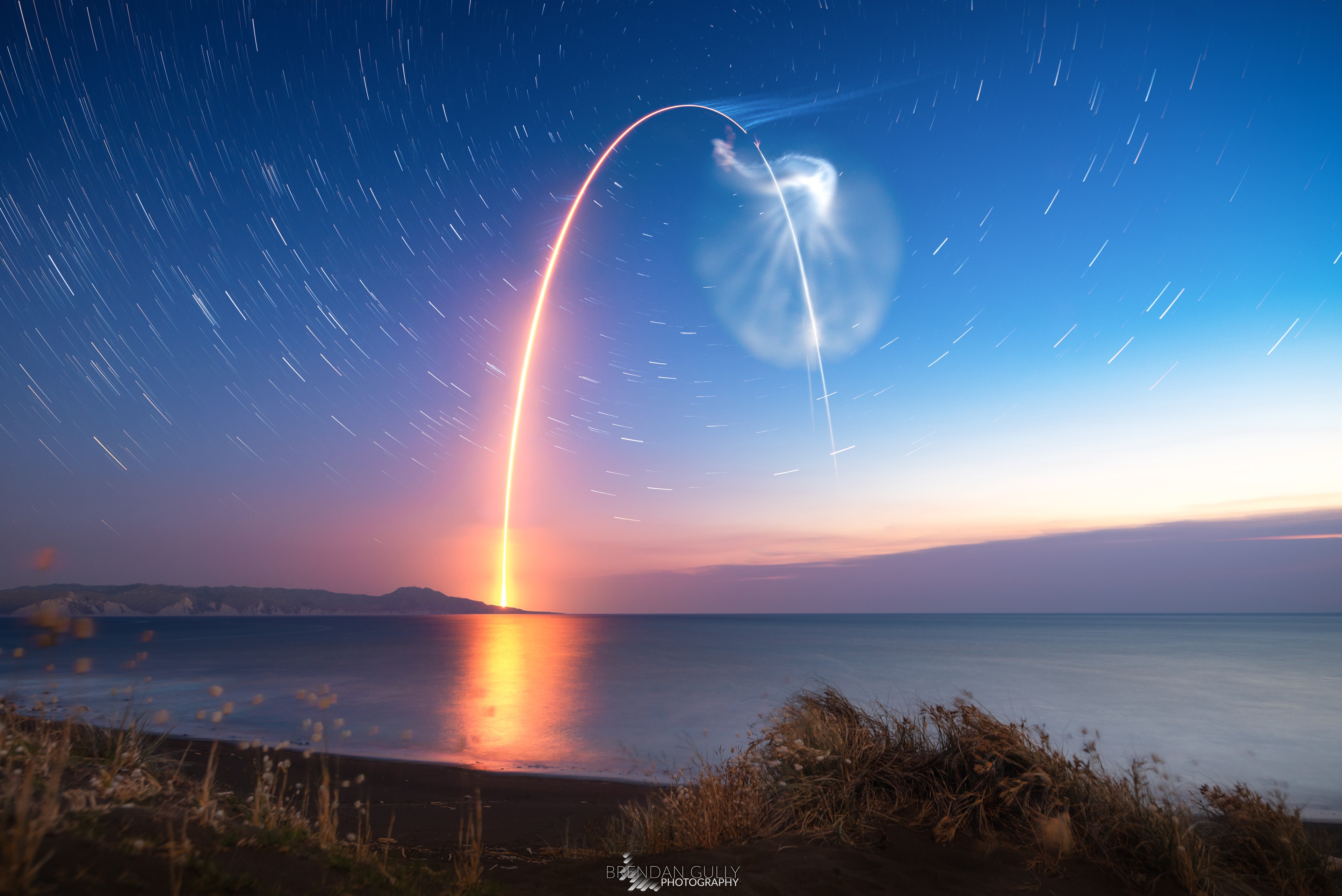 At sunset on December 6 a Rocket Lab Electron rocket was launched from a rotating planet. With multiple small satellites on board it departed on a mission to low Earth orbit dubbed Running Out of Fingers from Mahia Peninsula on New Zealand's north island. The fiery trace of the Electron's graceful launch arc is toward the south in this southern sea and skyscape. Drifting vapor trails and rocket exhaust plumes catch the sunlight even as the sky grows dark though, the setting Sun still shinning at altitude along the rocket's trajectory. Fixed to a tripod, the camera's perspective nearly aligns the peak of the rocket arc with the South Celestial Pole, but no bright star marks that location in the southern hemisphere's evening sky. Still, it's easy to find at the center of the star trail arcs in the timelapse composite.