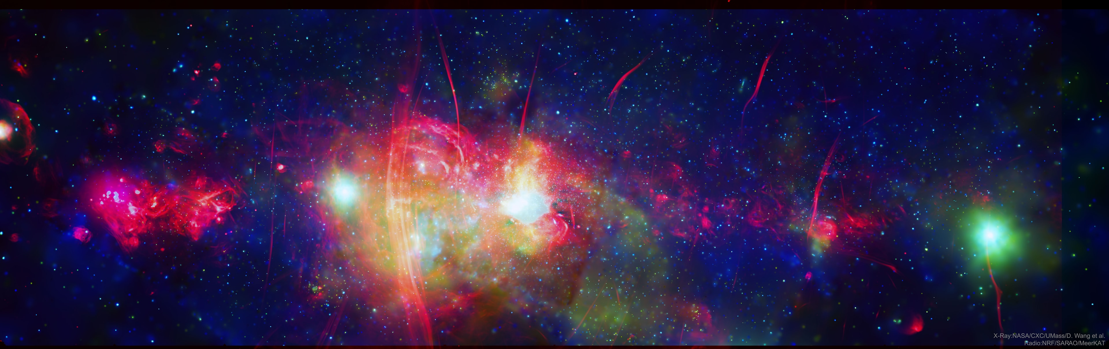 In how many ways does the center of our Galaxy glow?  This enigmatic region, about 26,000 light years away toward the constellation of the Archer (Sagittarius), glows in every type of light that we can see.  In the featured image, high-energy X-ray emission captured by NASA's orbiting Chandra X-Ray Observatory appears in green and blue, while low-energy radio emission captured by SARAO's ground-based MeerKAT telescope array is colored red. Just on the right of the colorful central region lies Sagittarius A (Sag A), a strong radio source that coincides with Sag A*, our Galaxy's central supermassive black hole. Hot gas surrounds Sag A, as well as a series of parallel radio filaments known as the Arc, seen just left of the image center.  Numerous unusual single radio filaments are visible around the image. Many stars orbit in and around Sag A, as well as numerous small black holes and dense stellar cores known as neutron stars and white dwarfs.  The Milky Way's central supermassive black hole is currently being imaged by the Event Horizon Telescope.   Activities: NASA Science at Home