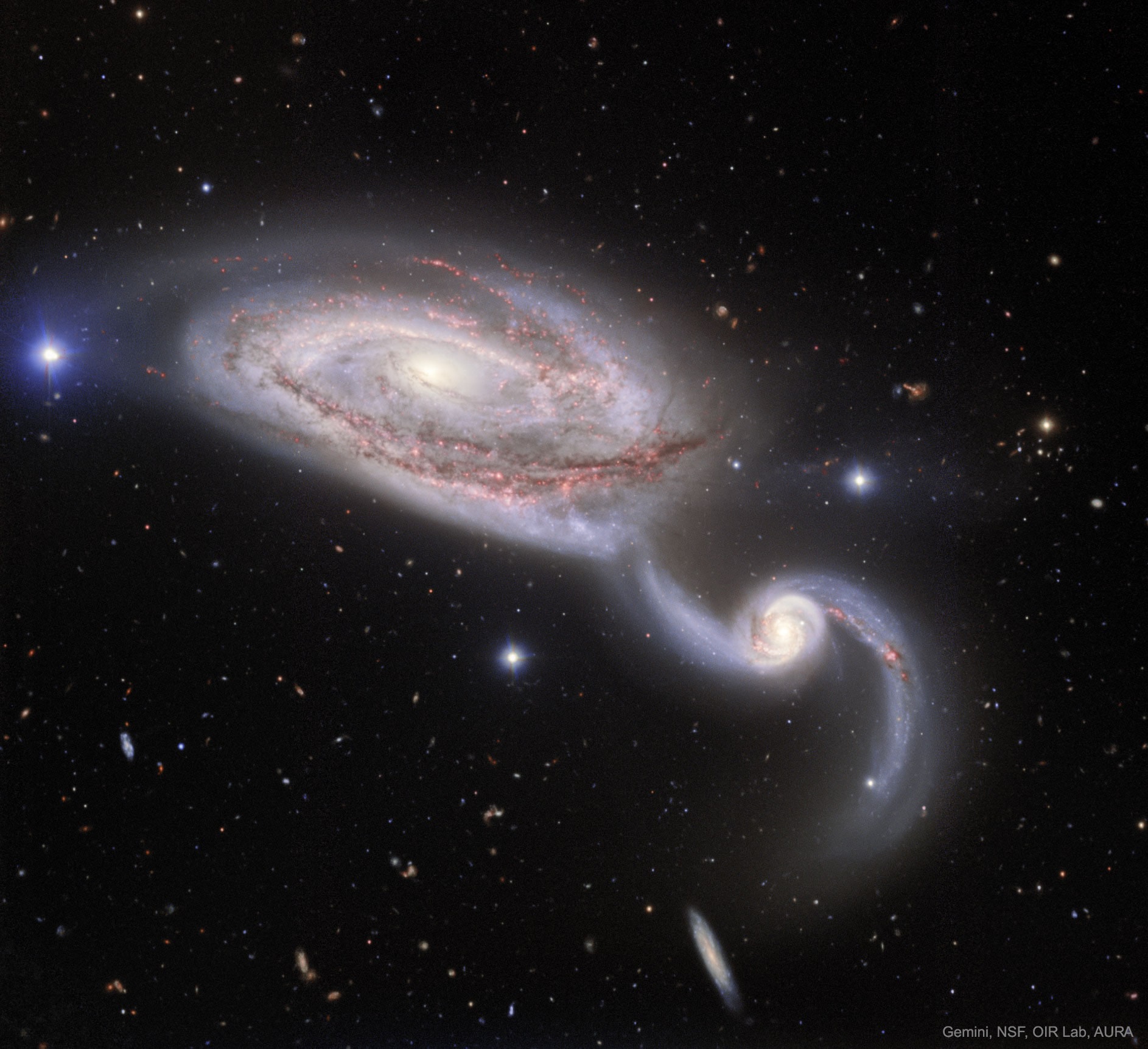 If you like slow dances, then this may be one for you.  A single turn in this dance takes several hundred million years.  Two galaxies, NGC 5394 and NGC 5395, slowly whirl about each other in a gravitational interaction that sets off a flourish of sparks in the form of new stars.  The featured image, taken with the Gemini North 8-meter telescope on Maunakea, Hawaii, USA, combines four different colors.  Emission from hydrogen gas, colored red, marks stellar nurseries where new stars drive the evolution of the galaxies.  Also visible are dark dust lanes that mark gas that will eventually become stellar nurseries. If you look carefully you will see many more galaxies in the background, some involved in their own slow cosmic dances.   APOD across world languages: Arabic, Catalan, Chinese (Beijing), Chinese (Taiwan), Croatian, Czech, Dutch, Farsi, French, French, German, Hebrew, Indonesian, Japanese, Korean, Montenegrin, Polish, Russian, Serbian, Slovenian,  Spanish and Ukrainian