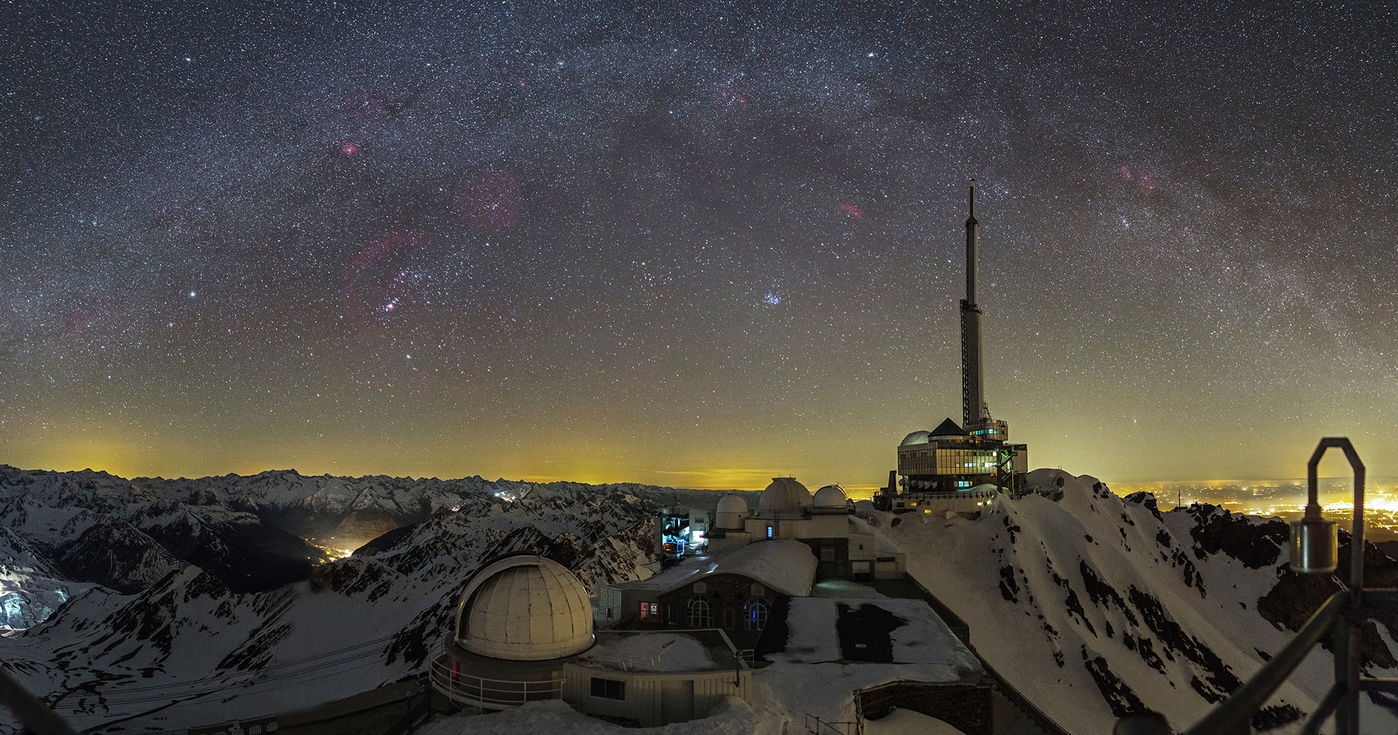 A surreal night skyscape, this panorama stitched from 12 photos looks to the west at an evening winter sky over Pic du Midi Observatory, Pyrenees Mountains, Planet Earth. Telescope domes and a tall communications tower inhabit the rugged foreground. On the right, lights from Tarbes, France about 35 kilometers away impinge on the designated dark sky site though, but more distant terrestrial lights seen toward the left are from cities in Spain. Stars and nebulae of the northern winter's Milky Way arc through the sky above. Known to the planet's night skygazers, the Pleiades and Hyades star clusters still hang over the western horizon near center. Captured in mid February the familiar stars of the constellation Orion are to the left and include the no longer fainting star Betelgeuse.