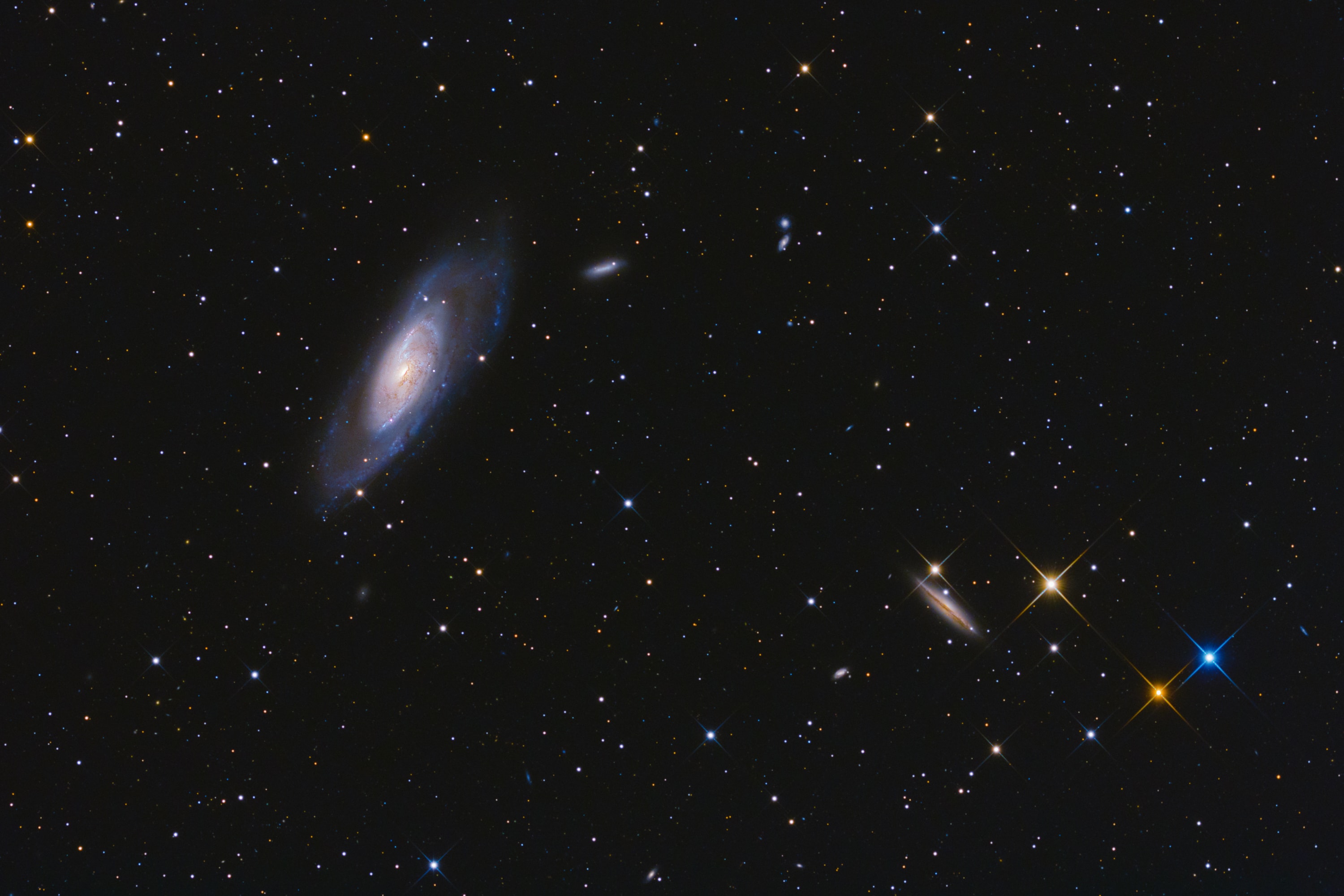 Big, bright, beautiful spiral, Messier 106 dominates this cosmic vista. The nearly two degree wide telescopic field of view looks toward the well-trained constellation Canes Venatici, near the handle of the Big Dipper. Also known as NGC 4258, M106 is about 80,000 light-years across and 23.5 million light-years away, the largest member of the Canes II galaxy group. For a far far away galaxy, the distance to M106 is well-known in part because it can be directly measured by tracking this galaxy's remarkable maser, or microwave laser emission. Very rare but naturally occurring, the maser emission is produced by water molecules in molecular clouds orbiting its active galactic nucleus. Another prominent spiral galaxy on the scene, viewed nearly edge-on, is NGC 4217 below and right of M106. The distance to NGC 4217 is much less well-known, estimated to be about 60 million light-years, but the bright spiky stars are in the foreground, well inside our own Milky Way galaxy. Even the existence of galaxies beyond the Milky Way was questioned 100 years ago in astronomy's Great Debate.   Experts Debate: How will humanity first discover extraterrestrial life?