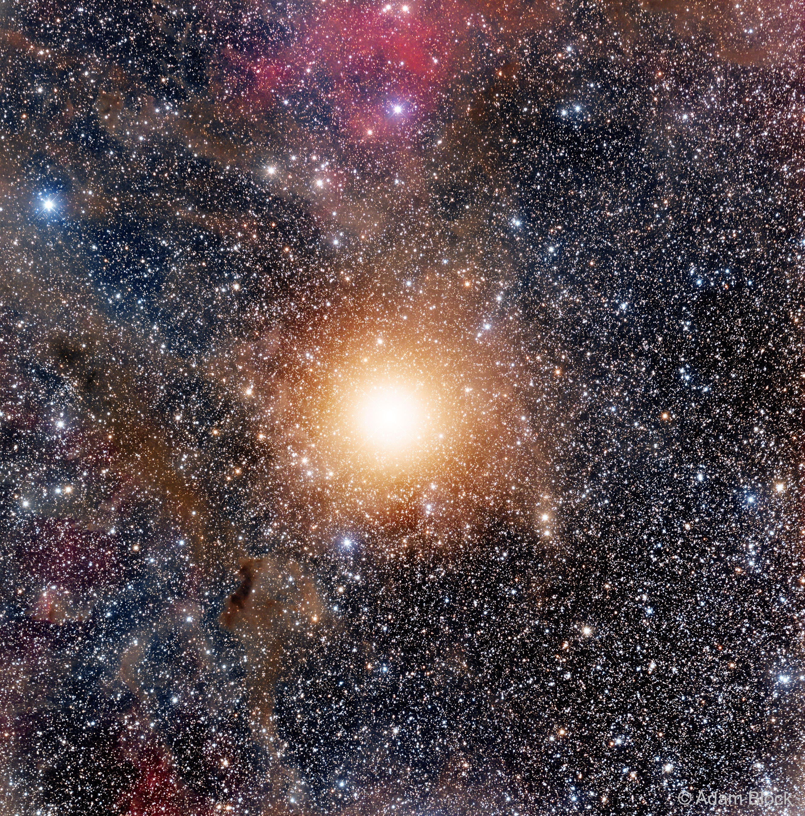 What's behind Betelgeuse? One of the brighter and more unusual stars in the sky, the red supergiant star Betelgeuse can be found in the direction of famous constellation Orion. Betelgeuse, however, is actually well in front of many of the constellation's other bright stars, and also in front of the greater Orion Molecular Cloud Complex.  Numerically, light takes about 700 years to reach us from Betelgeuse, but about 1,300 years to reach us from the Orion Nebula and its surrounding dust and gas.  All but the largest telescopes see Betelgeuse as only a point of light, but a point so bright that the inherent blurriness created by the telescope and Earth's atmosphere make it seem extended.  In the featured long-exposure image, thousands of stars in our Milky Way Galaxy can be seen in the background behind Betelgeuse, as well as dark dust from the Orion Molecular Cloud, and some red-glowing emission from hydrogen gas on the outskirts of the more distant Lambda Orionis Ring. Betelgeuse has recovered from appearing unusually dim over the past six months, but is still expected to explode in a spectacular supernova sometime in the next (about) 100,000 years.