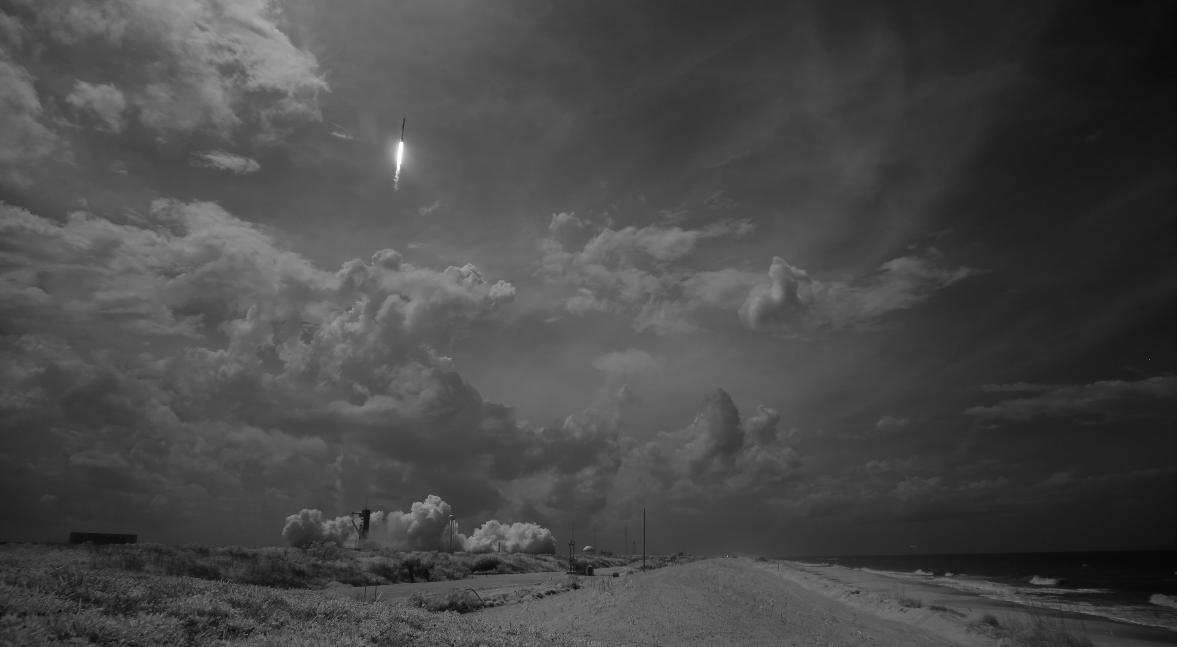 Clouds are white but the sky is dark in this snapshot of Launch Complex 39A at the Kennedy Space Center.  The dramatic daytime sky is partly due to the black and white photo captured with a digital camera at near-infrared wavelengths. Taken at 3:22 p.m. EDT Saturday May 30 the launch was pretty dramatic too as a Falcon 9 rocket lofted a Crew Dragon spacecraft towards low-Earth orbit. Astronauts Robert Behnken and Douglas Hurley were onboard, the first crew launched from a United States spaceport since the conclusion of the Space Shuttle Program in 2011. A few minutes after launch, the Falcon 9 first stage returned to land on Of Course I Still Love You (that's an autonomous spaceport drone ship ...) patiently waiting off the Florida coast. The two astronauts guided their craft to a successfull docking with the International Space Station’s Harmony module at 10:16 a.m. EDT Sunday May 31.