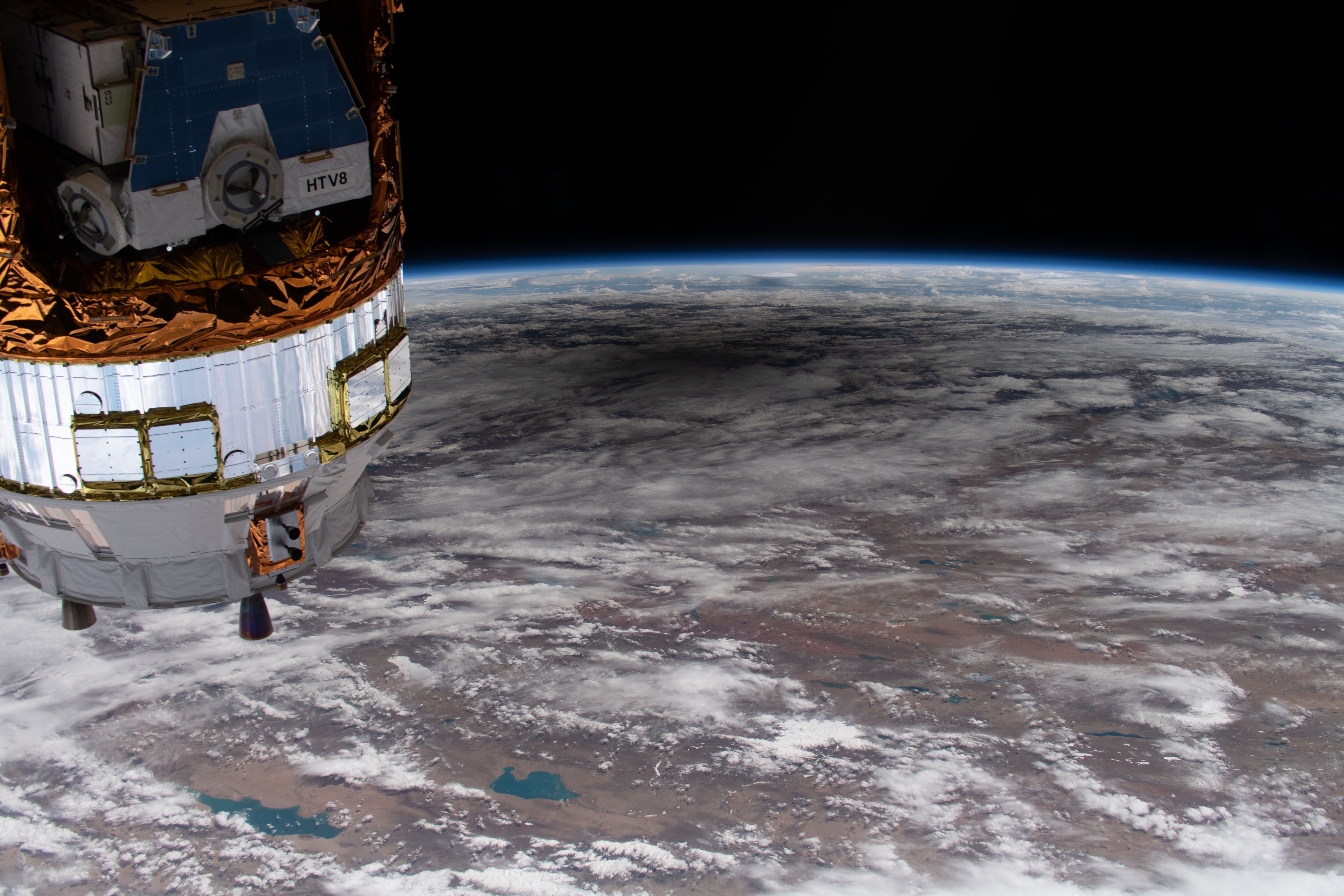The dark shadow of the New Moon reached out and touched planet Earth on June 21. A high definition camera outside the International Space Station captured its passing in this snapshot from low Earth orbit near the border of Kazakhstan and China. Of course those along the Moon's central shadow track below could watch the much anticipated annular eclipse of the Sun. In the foreground a cargo spacecraft is docked with the orbital outpost. It's the H-II Transfer Vehicle-9 from JAXA the Japan Aerospace Exploration Agency.   Gallery: Notable images of the Annular Solar Eclipse of 2020 June submitted to APOD