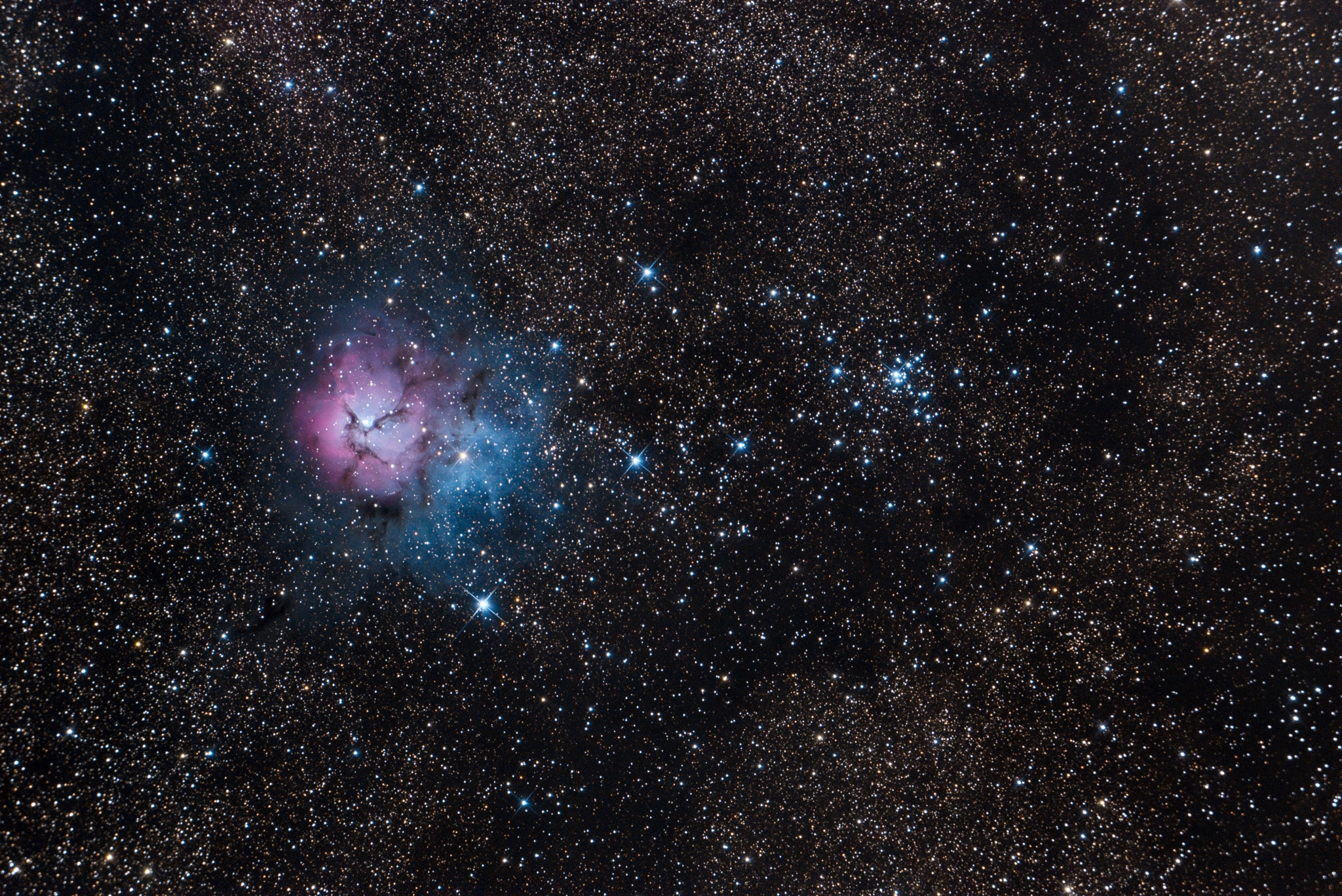 The beautiful Trifid Nebula, also known as Messier 20, is easy to find with a small telescope in the nebula rich constellation Sagittarius. About 5,000 light-years away, the colorful study in cosmic contrasts shares this well-composed, nearly 1 degree wide field with open star cluster Messier 21 (right). Trisected by dust lanes the Trifid itself is about 40 light-years across and a mere 300,000 years old. That makes it one of the youngest star forming regions in our sky, with newborn and embryonic stars embedded in its natal dust and gas clouds. Estimates of the distance to open star cluster M21 are similar to M20's, but though they share this gorgeous telescopic skyscape there is no apparent connection between the two. In fact, M21's stars are much older, about 8 million years old.