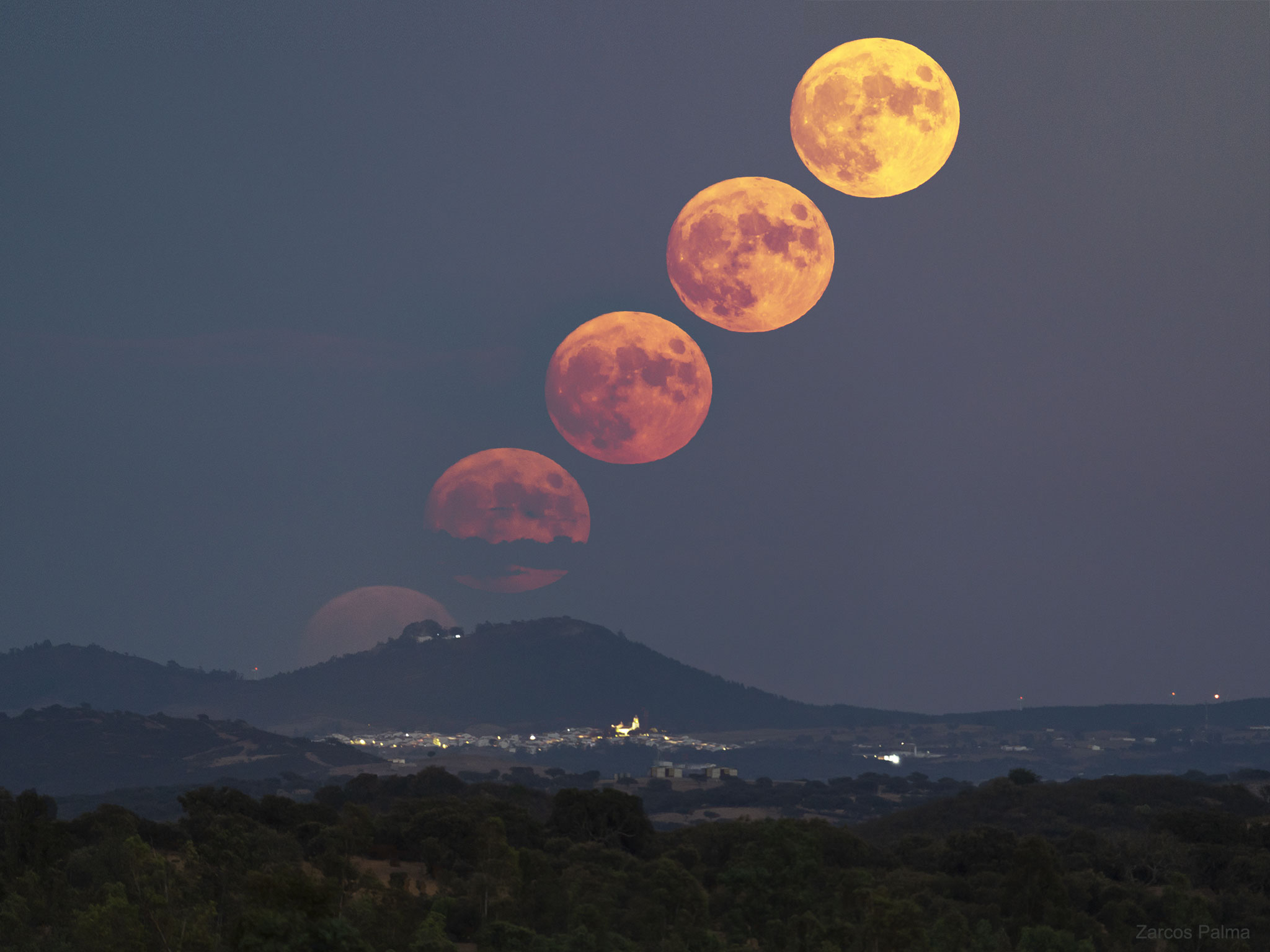 A rising moon can be a dramatic sight.  A rising Full Corn Moon was captured early this month in time-lapse with a telephoto lens from nearly 30 kilometers away -- making Earth's ascending half-degree companion appear unusually impressive.  The image was captured from Portugal, although much of the foreground -- including lights from the village of Puebla de Guzmán  -- is in Spain.  A Full Corn Moon is the name attributed to a full moon at this time of year by cultures of some northern indigenous peoples of the Americas, as it coincides with the ripening of corn.  Note that the Moon does not appear larger when it is nearer the horizon -- its seemingly larger size there is only an illusion.  The next full moon -- occurring at the beginning of next month -- will be known as the Full Harvest Moon as it occurs nearest in time to the northern autumnal equinox and the northern field harvests.