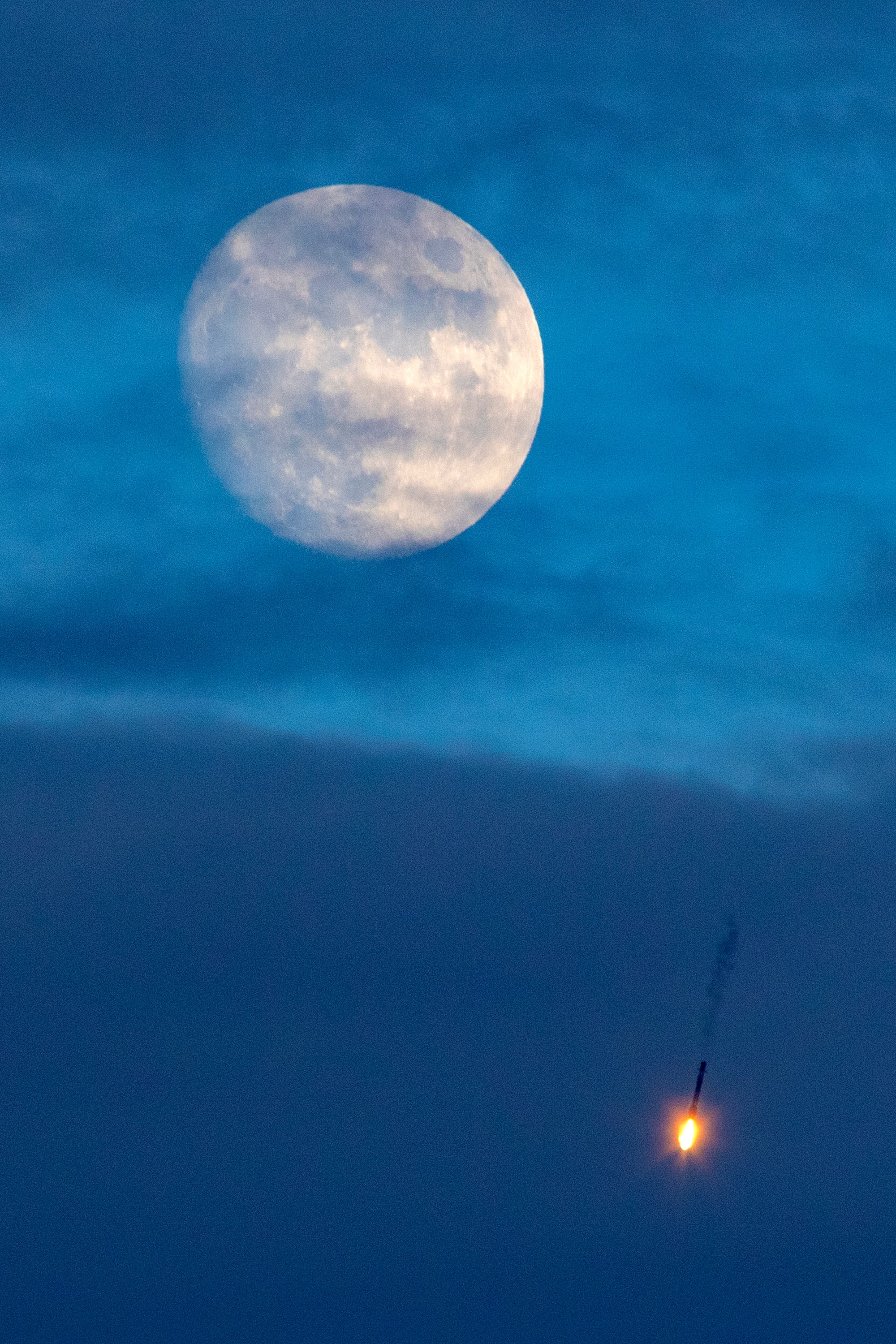 Illuminating planet Earth's night, full moons can have many names. This year the last full moon of northern hemisphere summer was on September 2, known to some as the Full Corn Moon. A few days earlier on August 30 this almost full moon rose just before sunset though, shining through cloudy skies over Cape Canaveral Air Force Station on Florida's Space Coast. A well-timed snapshot caught the glare of rocket engines firing below the lunar disk, a Falcon 9 rocket's first stage successfully returning to Cape Canaveral's landing zone 1. About 9 minutes earlier, the same SpaceX Falcon 9 rocket had launched the SAOCOM 1B satellite toward polar orbit. The fourth launch for this reusable Falcon 9 first stage, it was the first launch to a polar orbit from Cape Canaveral since 1969.