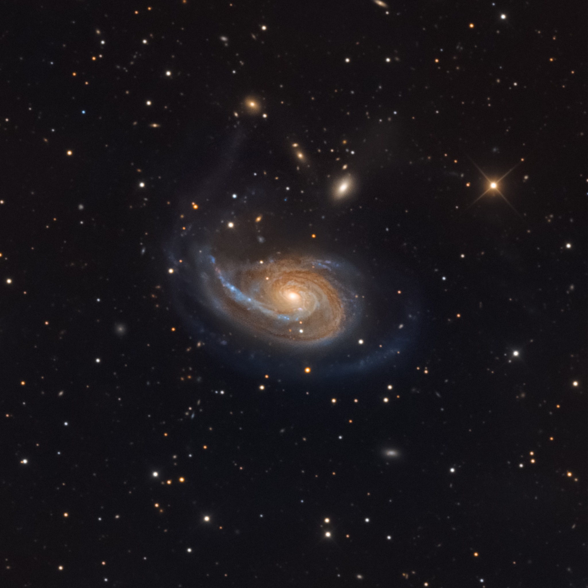 Peculiar spiral galaxy Arp 78 is found within the boundaries of the head strong constellation Aries, some 100 million light-years beyond the stars and nebulae of our Milky Way galaxy. Also known as NGC 772, the island universe is over 100,000 light-years across and sports a single prominent outer spiral arm in this detailed cosmic portrait. Its brightest companion galaxy, compact NGC 770, is toward the upper right of the larger spiral. NGC 770's fuzzy, elliptical appearance contrasts nicely with a spiky foreground Milky Way star in matching yellowish hues. Tracking along sweeping dust lanes and lined with young blue star clusters, Arp 78's large spiral arm is likely due to gravitational tidal interactions. Faint streams of material seem to connect Arp 78 with its nearby companion galaxies.