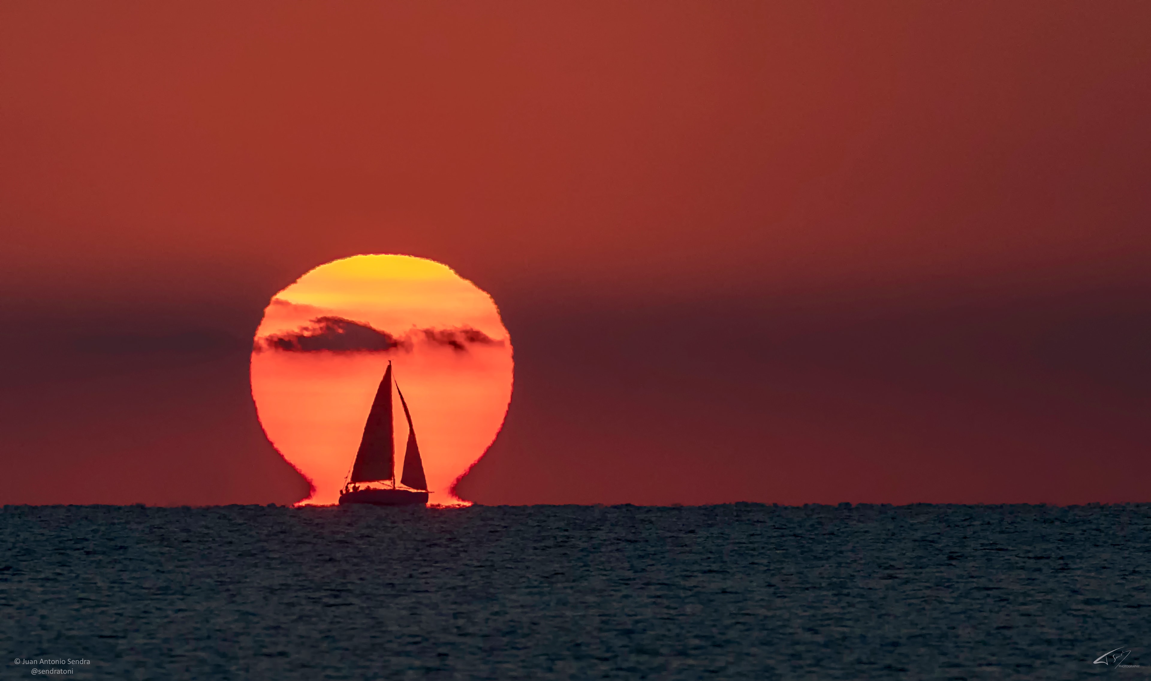 Capturing this sunrise required both luck and timing.  First and foremost, precise timing was needed to capture a sailboat crossing right in front of a rising Sun.  Additionally, by a lucky coincidence, the background Sun itself appears unusual -- it looks like the Greek letter Omega (Ω).  In reality, the Sun remained its circular self -- the Omega illusion was created by sunlight refracting through warm air just above the water.  Optically, the feet of the capital Omega are actually an inverted image of the Sun region just above it.  Although somewhat rare, optical effects caused by the Earth's atmosphere can make distant objects near the horizon -- including the Sun and Moon -- look quite unusual.  This single exposure image was taken over the Mediterranean Sea just over two weeks ago near Valencia, Spain.
