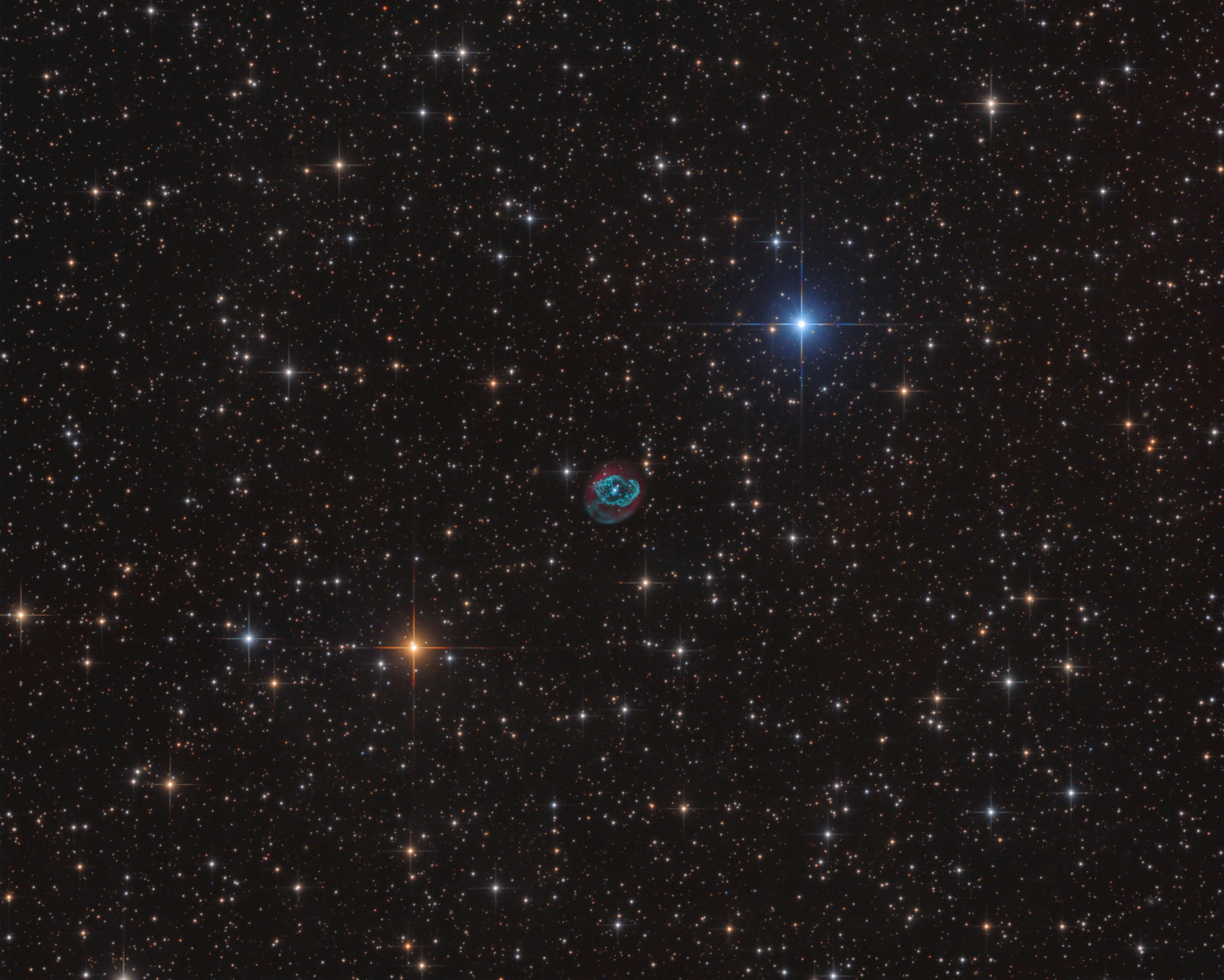 Planetary nebula Abell 78 stands out in this colorful telescopic skyscape. In fact the colors of the spiky Milky Way stars depend on their surface temperatures, both cooler (yellowish) and hotter (bluish) than the Sun. But Abell 78 shines by the characteristic emission of ionized atoms in the tenuous shroud of material shrugged off from an intensely hot central star. The atoms are ionized, their electrons stripped away, by the central star's energetic but otherwise invisible ultraviolet light. The visible blue-green glow of loops and filaments in the nebula's central region corresponds to emission from doubly ionized oxygen atoms, surrounded by strong red emission from electrons recombining with hydrogen atoms. Some 5,000 light-years distant toward the constellation Cygnus, Abell 78 is about three light-years across. A planetary nebula like Abell 78 represents a very brief final phase in stellar evolution that our own Sun will experience ... in about 5 billion years.