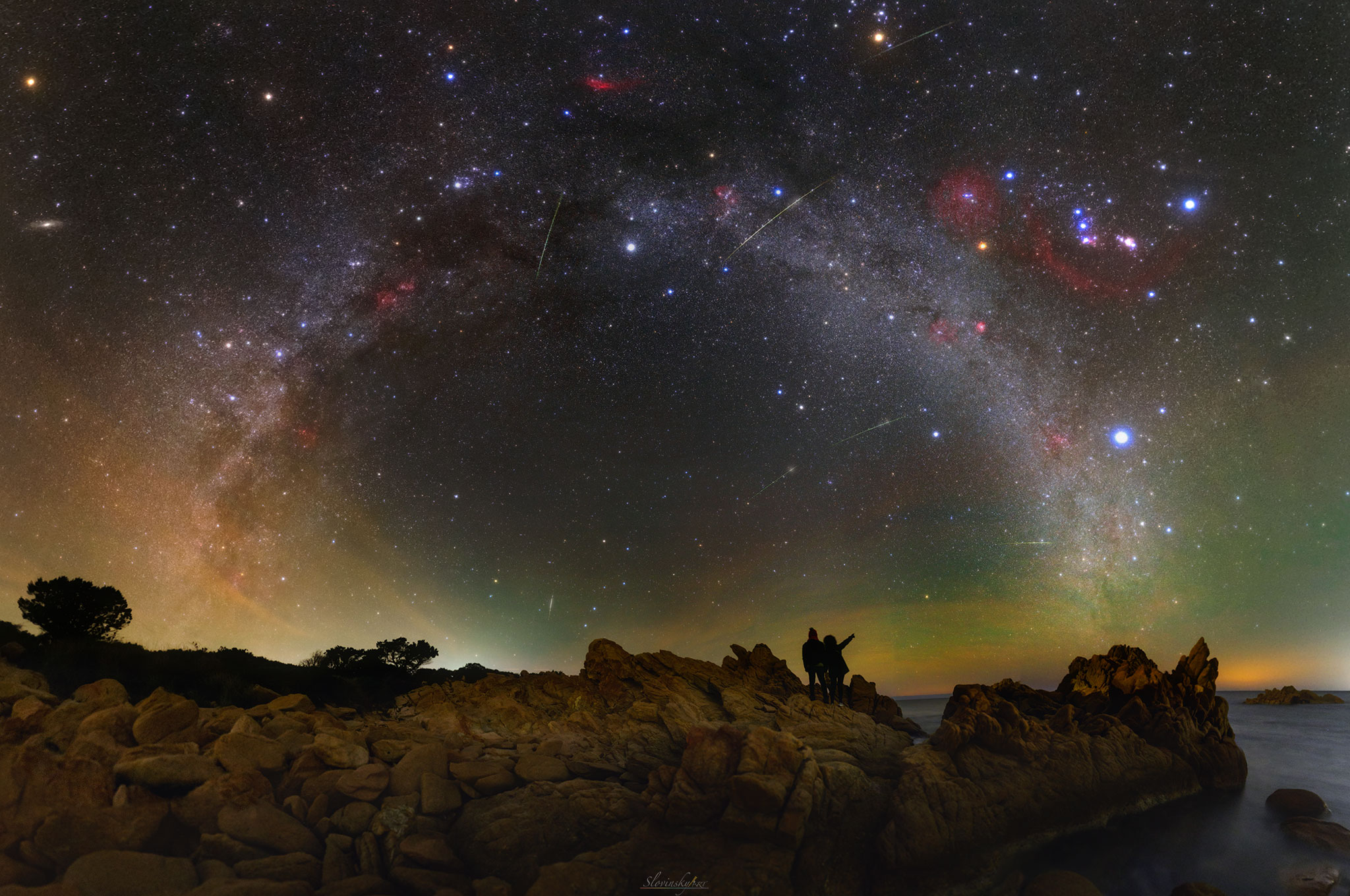 How many famous sky objects can you find in this image?  The featured dark sky composite combines over 60 exposures spanning over 220 degrees to create a veritable menagerie of night sky wonders. Visible celestial icons include the Belt of Orion, the Orion Nebula, the Andromeda Galaxy, the California Nebula, and bright stars Sirius and Betelgeuse.  You can verify that you found these, if you did, by checking an annotated version of the image.  A bit harder, though, is finding Polaris and the Big Dipper. Also discernible are several meteors from the Quandrantids meteor shower, red and green airglow, and two friends of the astrophotographer.  The picture was captured in January from Sardinia, Italy.  You can see sky wonders in your own night sky tonight -- including more meteors than usual -- because tonight is near peak of the yearly Orionids meteor shower.   News: NASA’s OSIRIS-REx Spacecraft Successfully Touches Asteroid