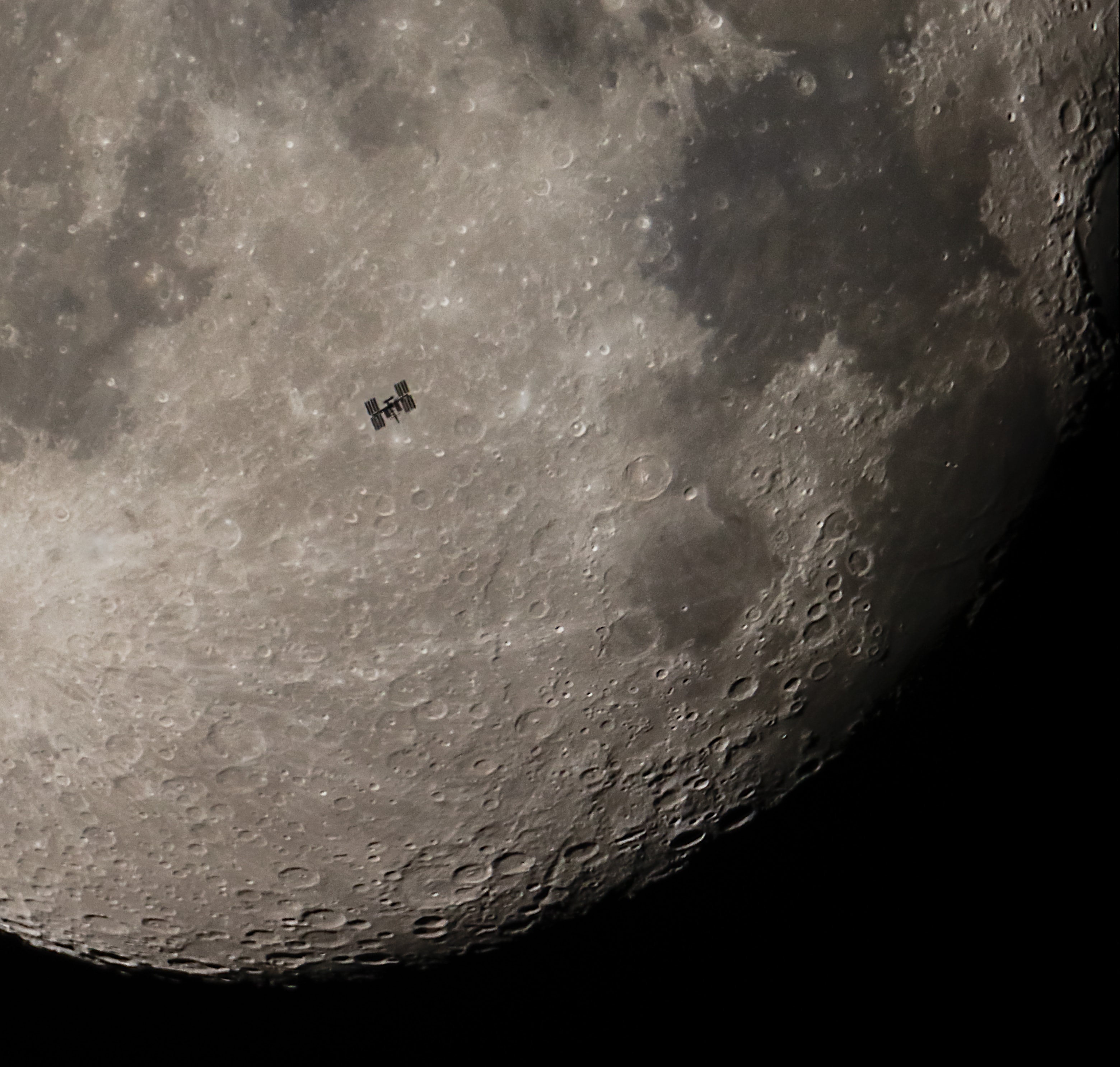 Completing one orbit of our fair planet in 90 minutes the International Space Station can easily be spotted by eye as a very bright star moving through the night sky. Have you seen it? The next time you do, you will have recognized the location of over 20 years of continuous human presence in space. In fact, the Expedition 1 crew to the ISS docked with the orbital outpost some 400 kilometers above the Earth on November 2, 2000. No telescope is required to spot the ISS flashing through the night. But this telescopic field of view does reveal remarkable details of the space station captured as it transited the waning gibbous moon on November 3, just one day after the space age milestone. The well-timed telescopic snapshot also contains the location of another inspirational human achievement. About 400,000 kilometers away, the Apollo 11 landing site on the dark, smooth lunar Sea of Tranquility is to the right of the ISS silhouette.
