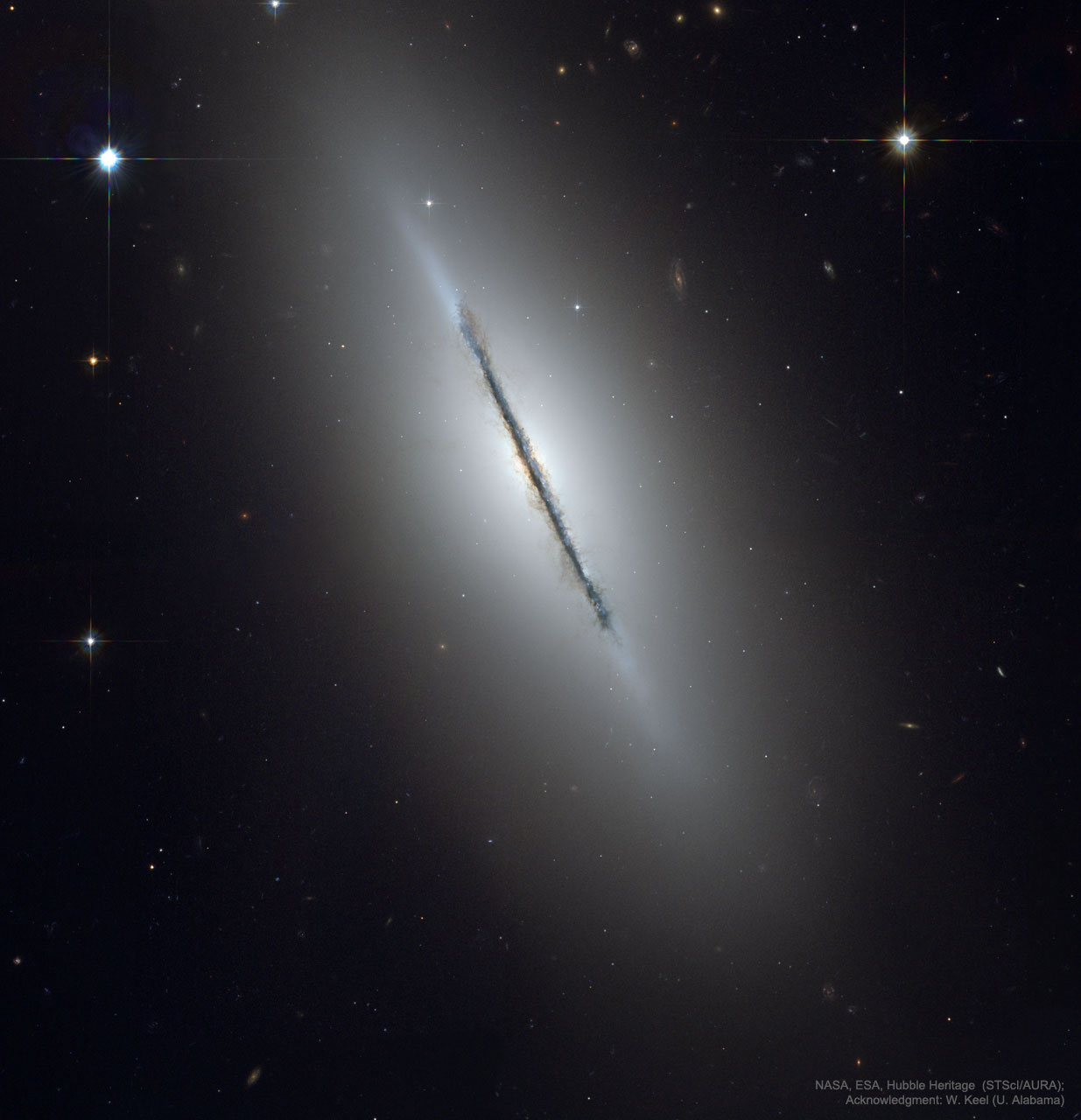 Why is this galaxy so thin?  Many disk galaxies are just as thin as NGC 5866, pictured here, but are not seen edge-on from our vantage point.  One galaxy that is situated edge-on is our own Milky Way Galaxy.  Classified as a lenticular galaxy, NGC 5866 has numerous and complex dust lanes appearing dark and red, while many of the bright stars in the disk give it a more blue underlying hue.  The blue disk of young stars can be seen extending past the dust in the extremely thin galactic plane, while the bulge in the disk center appears tinged more orange from the older and redder stars that likely exist there. Although similar in mass to our Milky Way Galaxy, light takes about 60,000 years to cross NGC 5866, about 30 percent less than light takes to cross our own Galaxy. In general, many disk galaxies are very thin because the gas that formed them collided with itself as it rotated about the gravitational center. Galaxy NGC 5866 lies about 44 million light years distant toward the constellation of the Dragon (Draco).    Almost Hyperspace: Random APOD Generator
