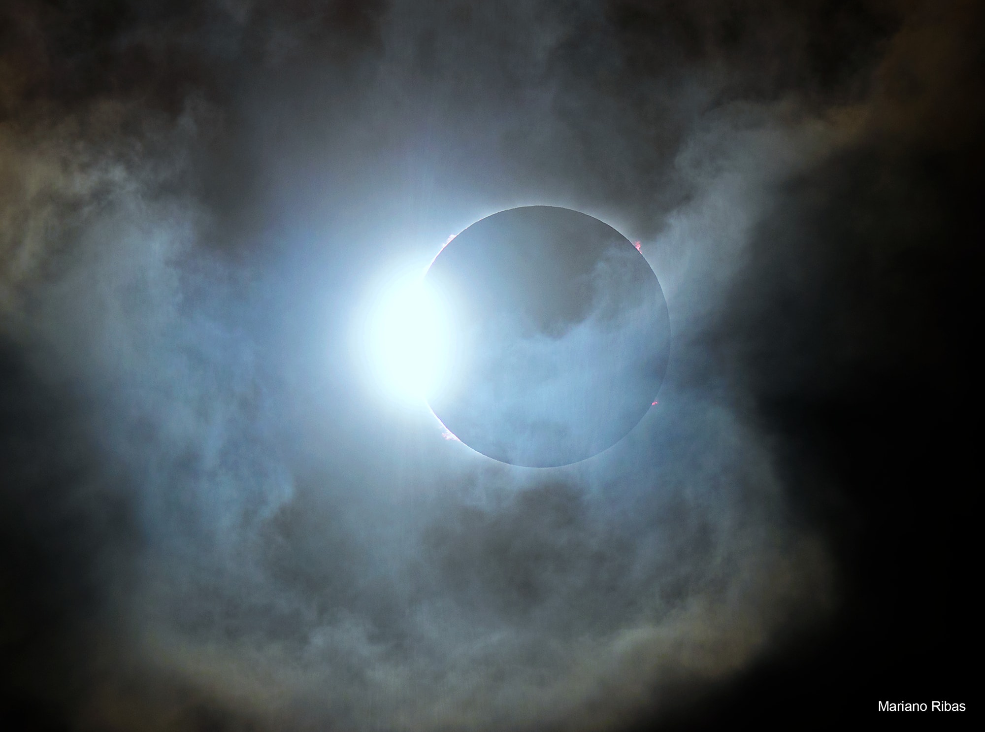 When the shadow of the Moon raced across planet Earth's southern hemisphere on December 14, sky watchers along the shadow's dark central path were treated to the only total solar eclipse of 2020. During the New Moon's shadow play this glistening diamond ring was seen for a moment, even in cloudy skies. Known as the diamond ring effect, the transient spectacle actually happens twice. Just before and immediately after totality, a thin sliver of solar disk visible behind the Moon's edge creates the appearance of a shiny jewel set in a dark ring. This dramatic snapshot from the path of totality in northern Patagonia, Argentina captures this eclipse's second diamond ring, along with striking solar prominences lofted beyond the edge of the Moon's silhouette.