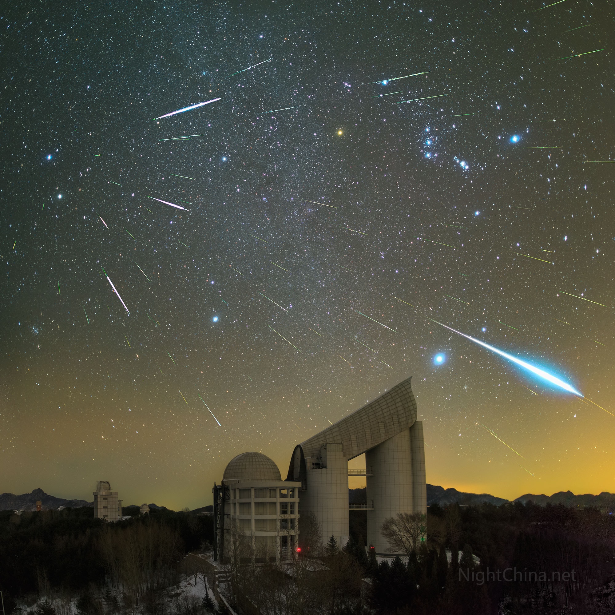 Where do Geminid meteors come from?  In terms of location on the sky, as the featured image composite beautifully demonstrates, the sand-sized bits of rock that create the streaks of the Geminids meteor shower appear to flow out from the constellation of Gemini. In terms of parent body, Solar System trajectories point to the asteroid 3200 Phaethon -- but this results in a bit of a mystery since that unusual object appears mostly dormant.  Perhaps, 3200 Phaethon undergoes greater dust-liberating events than we know. Over 50 meteors including a bright fireball were captured during the peak of the 2015 Geminids Meteor Shower streaking above Xinglong Observatory in China.  The Geminids of December are one of the most predictable and active meteor showers.  This year's Geminids peak tonight and should be particularly good because, in part, the nearly new Moon will only rise toward dawn and so not brighten the sky.