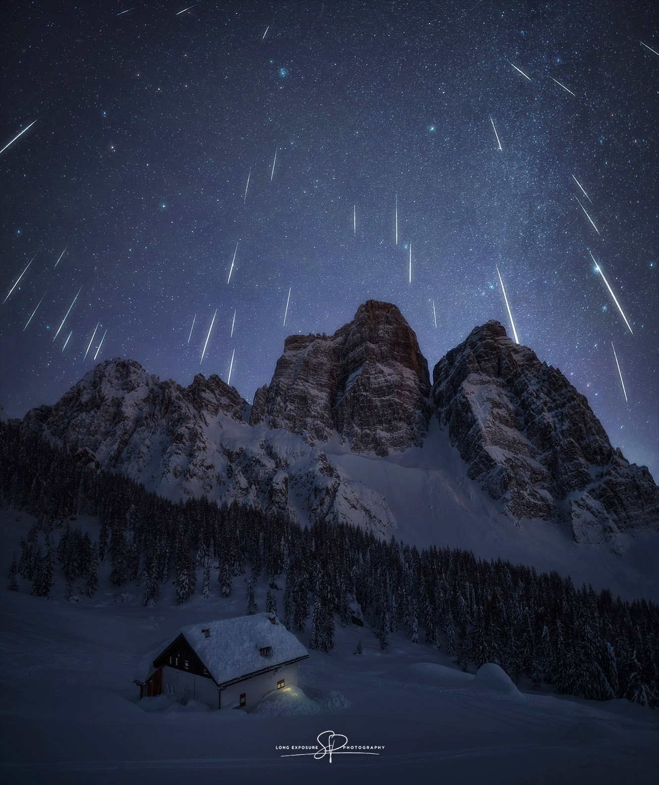 Taken over the course of an hour shortly after local midnight on December 13, 35 exposures were used to create this postcard from Earth. The composited night scene spans dark skies above the snowy Italian Dolomites during our fair planet's annual Geminid meteor shower. Sirius, alpha star of Canis Major and the brightest star in the night, is grazed by a meteor streak on the right. The Praesepe star cluster, also known as M44 or the Beehive cluster, itself contains about a thousand stars but appears as a smudge of light far above the southern alpine peaks near the top. The shower's radiant is off the top of the frame though, near Castor and Pollux the twin stars of Gemini. The radiant effect is due to perspective as the parallel meteor tracks appear to converge in the distance. As Earth sweeps through the dust trail of asteroid 3200 Phaethon, the dust that creates Gemini's meteors enters Earth's atmosphere traveling at about 22 kilometers per second.   Submitted to APOD: Notable images of the 2020 Geminids Meteor Shower
