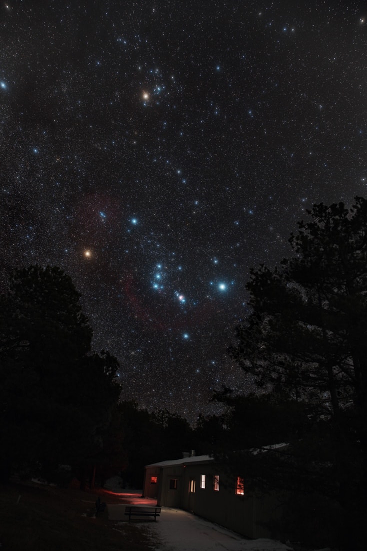 Orion always seems to come up sideways on northern winter evenings. Those familiar stars of the constellation of the Hunter are caught above the trees in this colorful night skyscape. Not a star at all but still visible to eye, the Great Nebula of Orion shines below the Hunter's belt stars. The camera's exposure reveals the stellar nursery's faint pinkish glow. Betelgeuse, giant star at Orion's shoulder, has the color of warm and cozy terrestrial lighting, but so does another familiar stellar giant, Aldebaran. Alpha star of the constellation Taurus the Bull, Aldebaran anchors the recognizable V-shape traced by the Hyades Cluster toward the top of the starry frame.