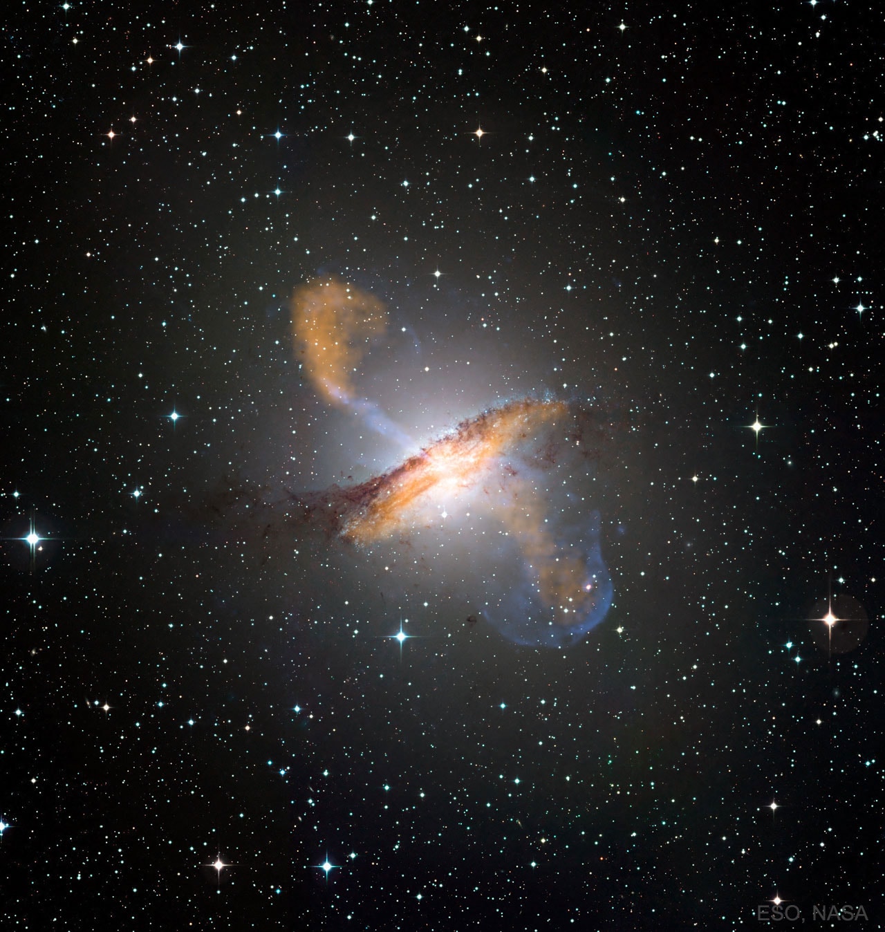 The jets emanating from Centaurus A are over a million light years long. These jets of streaming plasma, expelled by a giant black hole in the center of this spiral galaxy,  light up this composite image of Cen A. Exactly how the central black hole expels infalling matter remains unknown. After clearing the galaxy, however, the jets inflate large radio bubbles that likely glow for millions of years. If energized by a passing gas cloud, the radio bubbles can even light up again after billions of years. X-ray light is depicted in the featured composite image in blue, while microwave light is colored orange.  The base of the jet in radio light shows details of the innermost light year of the central jet.