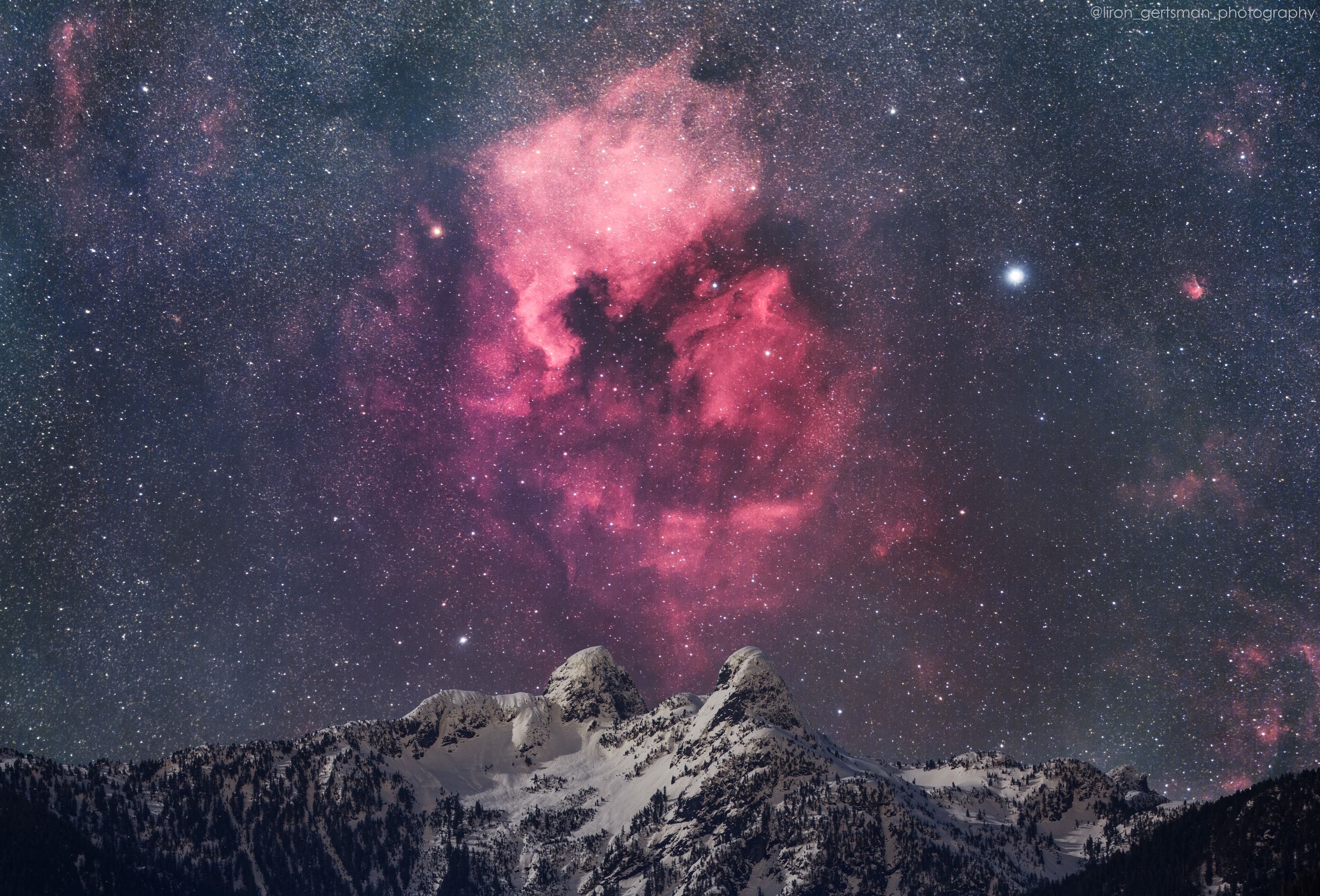 On January 21, light from the Moon near first quarter illuminated the foreground in this snowy mountain and night scene. Known as The Lions, the striking pair of mountain peaks are north of Vancouver, British Colombia, Canada, North America, planet Earth. Poised above the twin summits, left of Deneb alpha star of the constellation Cygnus, are emission regions NGC 7000 and IC 5070. Part of a large star forming complex about 1,500 light-years from Vancouver, they shine with the characteristic red glow of atomic hydrogen gas. Outlines of the bright emission regions suggest their popular names, The North America Nebula and The Pelican Nebula. The well-planned, deep nightscape is a composite of consecutive exposures made with a modified digital camera and telephoto lens. Foreground exposures were made with camera fixed to a tripod, background exposures were made tracking the sky. The result preserves sharp natural detail and reveals a range of brightness and color that your eye can't quite see on its own.