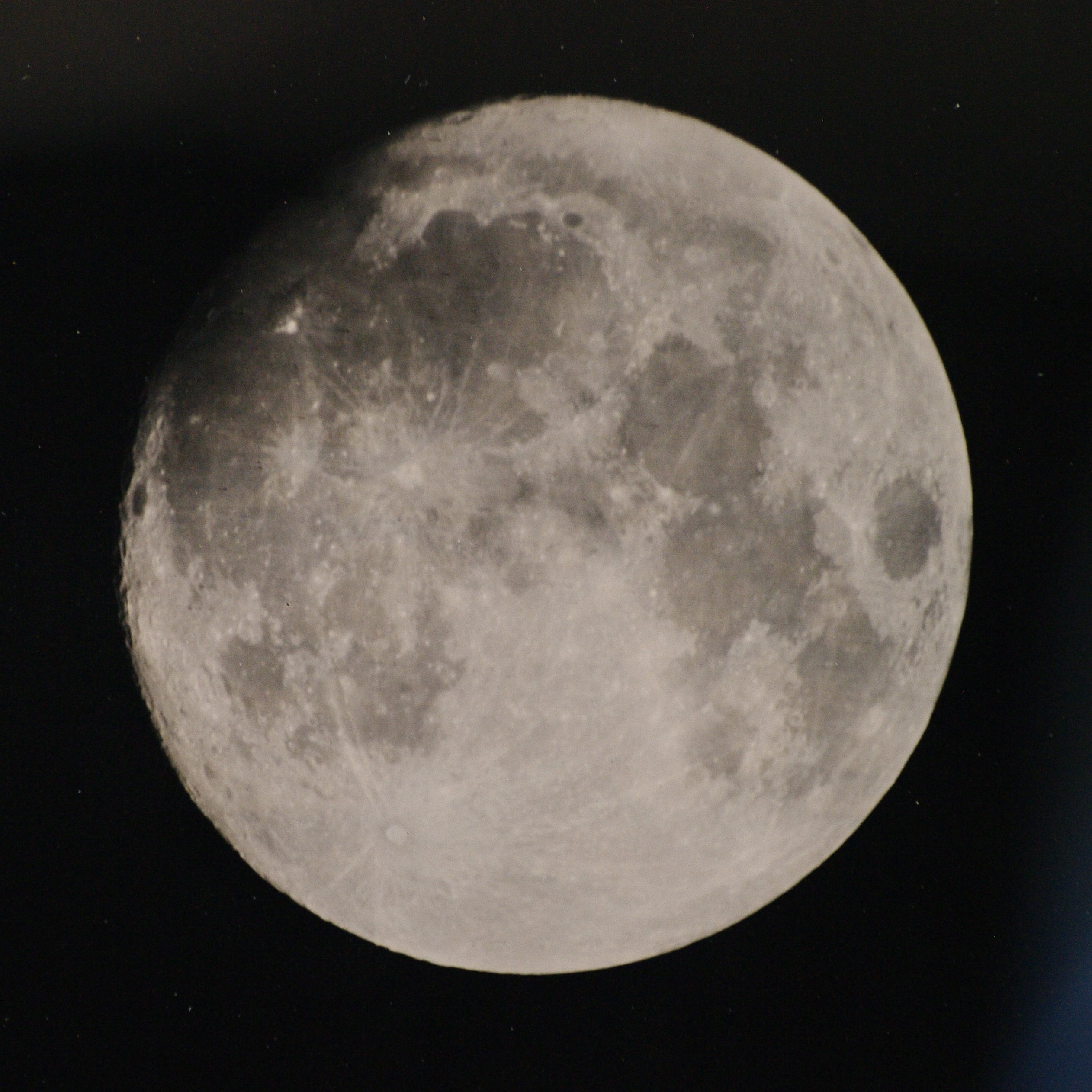 In the mid 19th century, one of the first photographic technologies used to record the lunar surface was the wet-plate collodion process, notably employed by British astronomer Warren De la Rue. To capture an image, a thick, transparent mixture was used to coat a glass plate, sensitized with silver nitrate, exposed at the telescope, and then developed to create a negative image on the plate. To maintain photographic sensitivity, the entire process, from coating to exposure to developing, had to be completed before the plate dried, in a span of about 10 to 15 minutes. This modern version of a wet-plate collodion image celebrates lunar photography's early days, reproducing the process using modern chemicals to coat a glass plate from a 21st century hardware store. Captured last November 28 with an 8x10 view camera and backyard telescope, it faithfully records large craters, bright rays, and dark, smooth mare of the waxing gibbous Moon. Subsequently digitized, the image on the plate was 8.5 centimeters in diameter and exposed while tracking for 2 minutes. The wet plate's effective photographic sensitivity was about ISO 1.  In your smart phone, the camera sensor probably has a photographic sensitivity range of ISO 100 to 6400 (and needs to be kept dry ...).