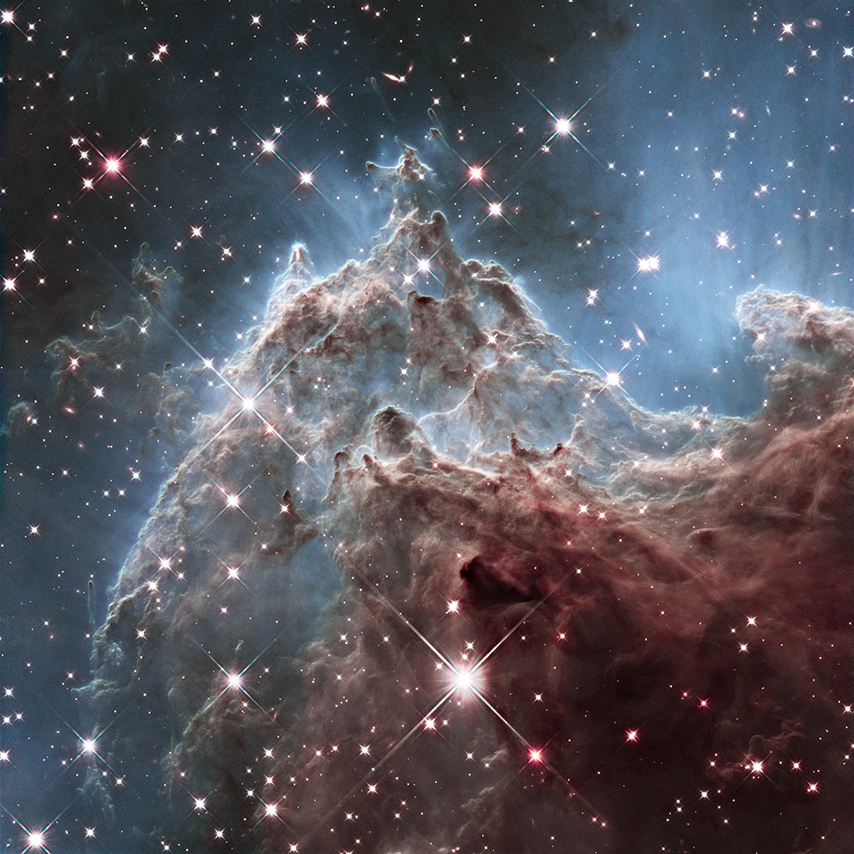 This fantastic skyscape lies near the edge of NGC 2174 a star forming region about 6,400 light-years away in the nebula-rich constellation of Orion. It follows mountainous clouds of gas and dust carved by winds and radiation from the region's newborn stars, now found scattered in open star clusters embedded around the center of NGC 2174, off the top of the frame. Though star formation continues within these dusty cosmic clouds they will likely be dispersed by the energetic newborn stars within a few million years. Recorded at infrared wavelengths by the Hubble Space Telescope in 2014, the interstellar scene spans about 6 light-years. Scheduled for launch in 2021, the James Webb Space Telescope is optimized for exploring the Universe at infrared wavelengths.