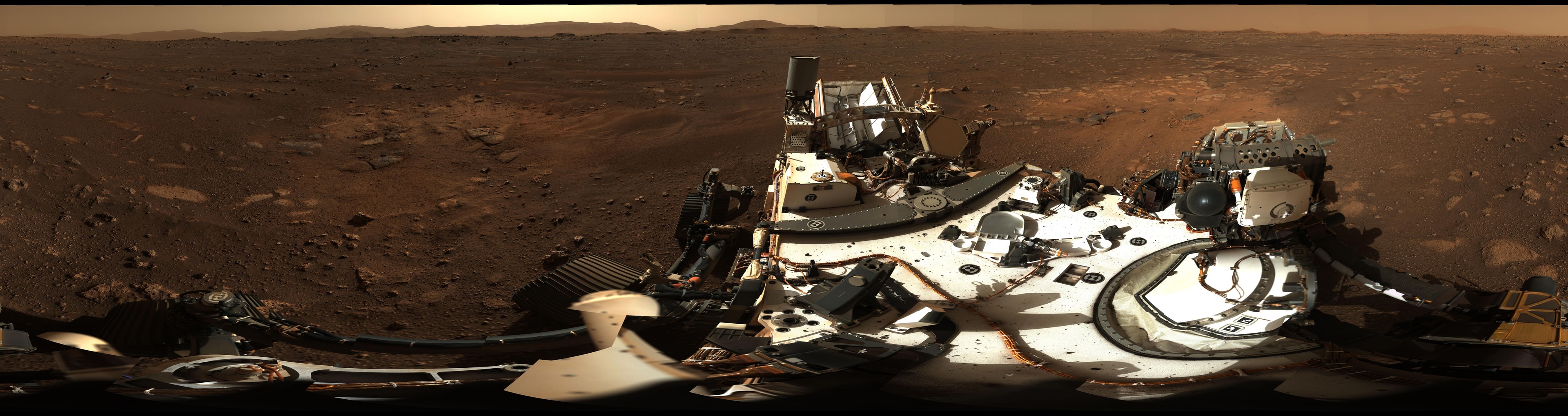 Stitched together on planet Earth, 142 separate images make up this 360 degree panorama from the floor of Jezero Crater on Mars. The high-resolution color images were taken by the Perseverance rover's zoomable Mastcam-Z during mission sol 3, also known as February 21, 2021. In the foreground of Mastcam-Z's view is the car-sized rover's deck. Broad light-colored patches in the martian soil just beyond it were scoured by descent stage rocket engines during the rover's dramatic arrival on February 18. The rim of 45 kilometer-wide Jezero Crater rises in the distance. In the coming sols, Perseverance will explore the ancient lake-delta system in the crater, hunting for signs of past microscopic life and collecting samples for potential future return to planet Earth.