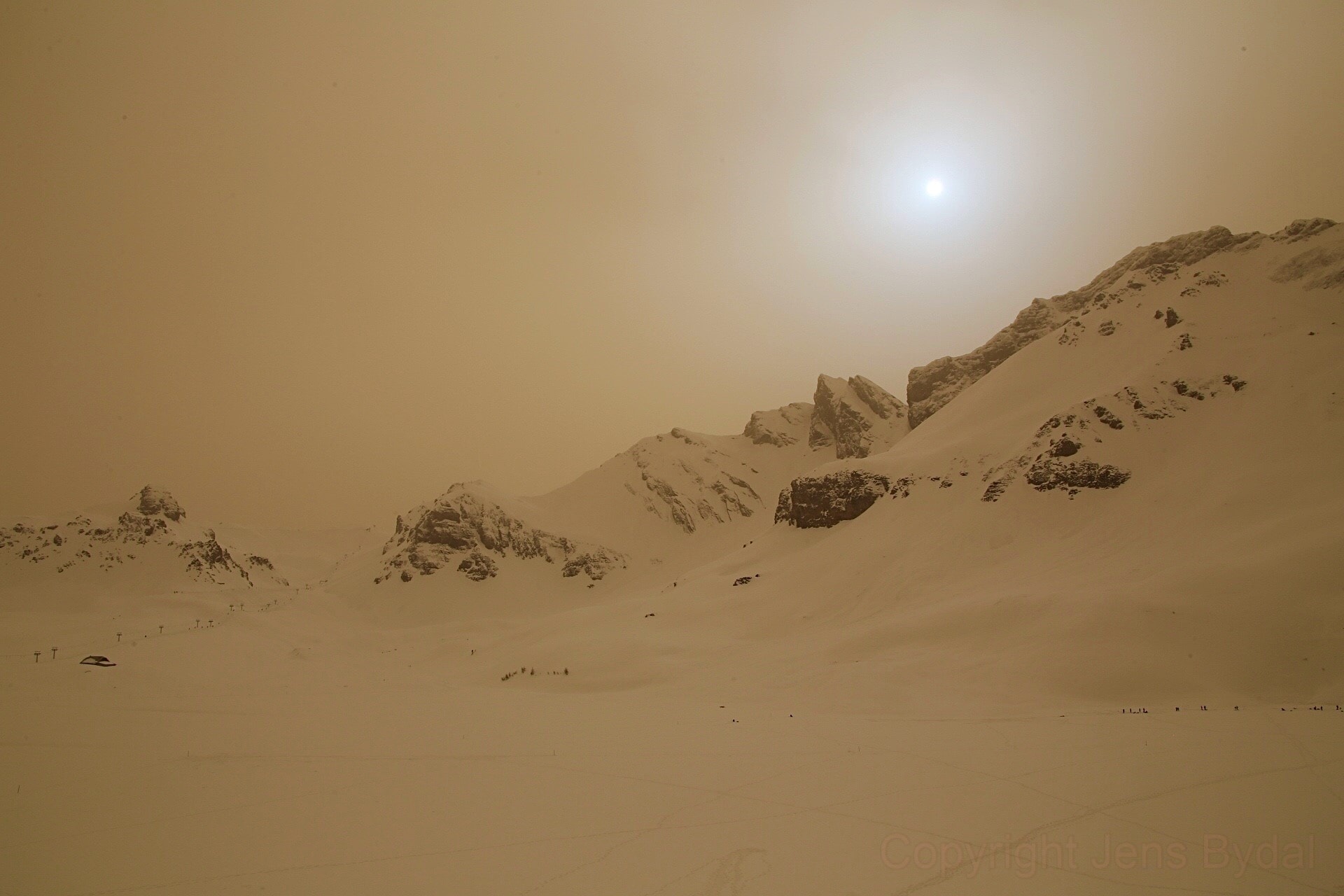 Taken on February 6, this snowy mountain and skyscape was captured near Melchsee-Frutt, central Switzerland, planet Earth. The reddish daylight and blue tinted glow around the afternoon Sun are colors of the Martian sky, though. Of course both worlds have the same Sun. From Mars, the Sun looks only about half as bright and 2/3 the size compared to its appearance from Earth. Lofted from the surface of Mars, fine dust particles suspended in the thin Martian atmosphere are rich in the iron oxides that make the Red Planet red. They tend to absorb blue sunlight giving a red tinge to the Martian sky, while forward scattering still makes the light appear relatively bluish near the smaller, fainter Martian Sun. Normally Earth's denser atmosphere strongly scatters blue light, making the terrestrial sky blue. But on February 6 a huge cloud of dust blown across the Mediterranean from the Sahara desert reached the Swiss Alps, dimming the Sun and lending that Alpine afternoon the colors of the Martian sky. By the next day, only the snow was left covered with reddish dust.   News from Mars: NASA Perseverance Coverage