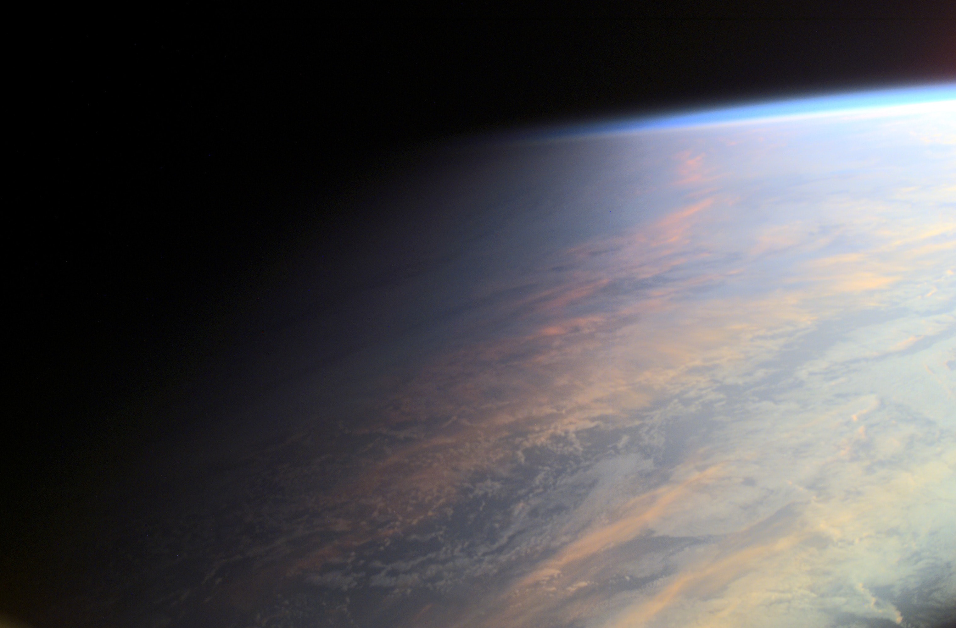 No sudden, sharp boundary marks the passage of day into night in this gorgeous view of ocean and clouds over our fair planet Earth. Instead, the shadow line or terminator is diffuse and shows the gradual transition to darkness we experience as twilight. With the Sun illuminating the scene from the right, the cloud tops reflect gently reddened sunlight filtered through the dusty troposphere, the lowest layer of the planet's nurturing atmosphere. A clear high altitude layer, visible along the dayside's upper edge, scatters blue sunlight and fades into the blackness of space. This picture was taken in June of 2001 from the International Space Station orbiting at an altitude of 211 nautical miles. But you can check out the vital signs of Planet Earth Now.  Celebrate: Earth Day