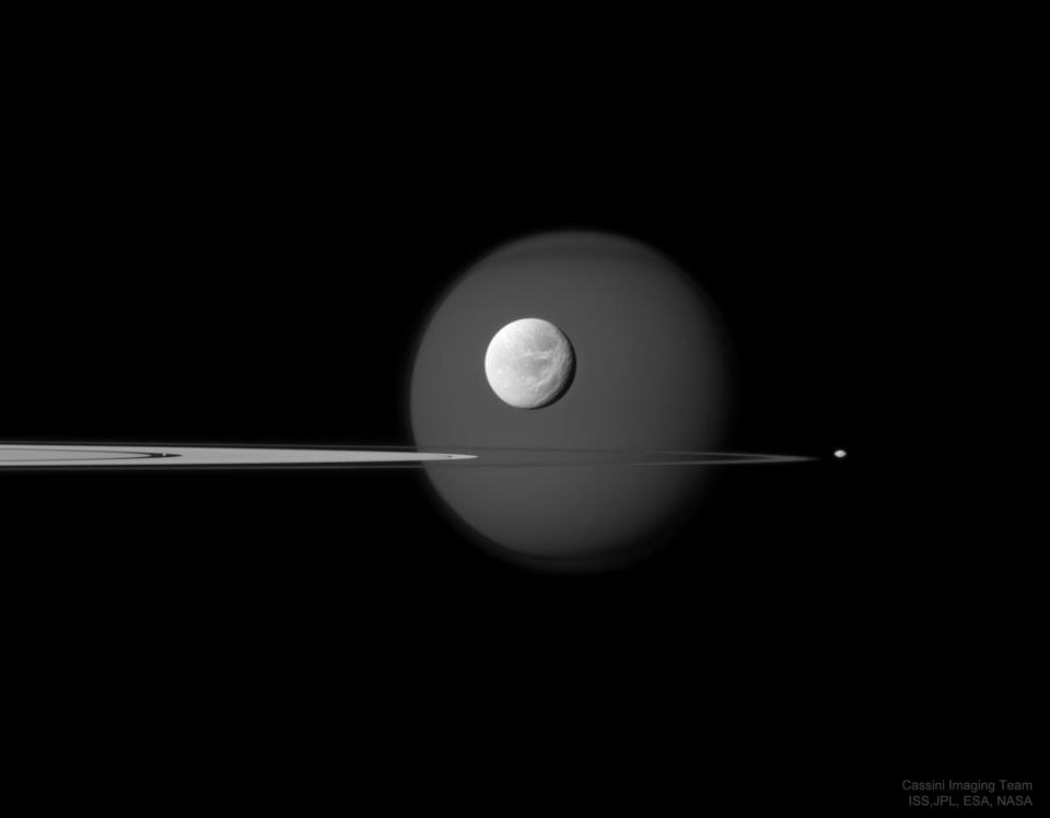 Four moons are visible on the featured image -- can you find them all? First -- and farthest in the background -- is Titan, the largest moon of Saturn and one of the larger moons in the Solar System.  The dark feature across the top of this perpetually cloudy world is the north polar hood. The next most obvious moon is bright Dione, visible in the foreground, complete with craters and long ice cliffs. Jutting in from the left are several of Saturn's expansive rings, including Saturn's A ring featuring the dark Encke Gap. On the far right, just outside the rings, is Pandora, a moon only 80-kilometers across that helps shepherd Saturn's F ring. The fourth moon?  If you look closely inside Saturn's rings, in the Encke Gap, you will find a speck that is actually Pan. Although one of Saturn's smallest moons at 35-kilometers across, Pan is massive enough to help keep the Encke gap relatively free of ring particles. After more than a decade of exploration and discovery, the Cassini spacecraft ran low on fuel in 2017 and was directed to enter Saturn's atmosphere, where it surely melted.