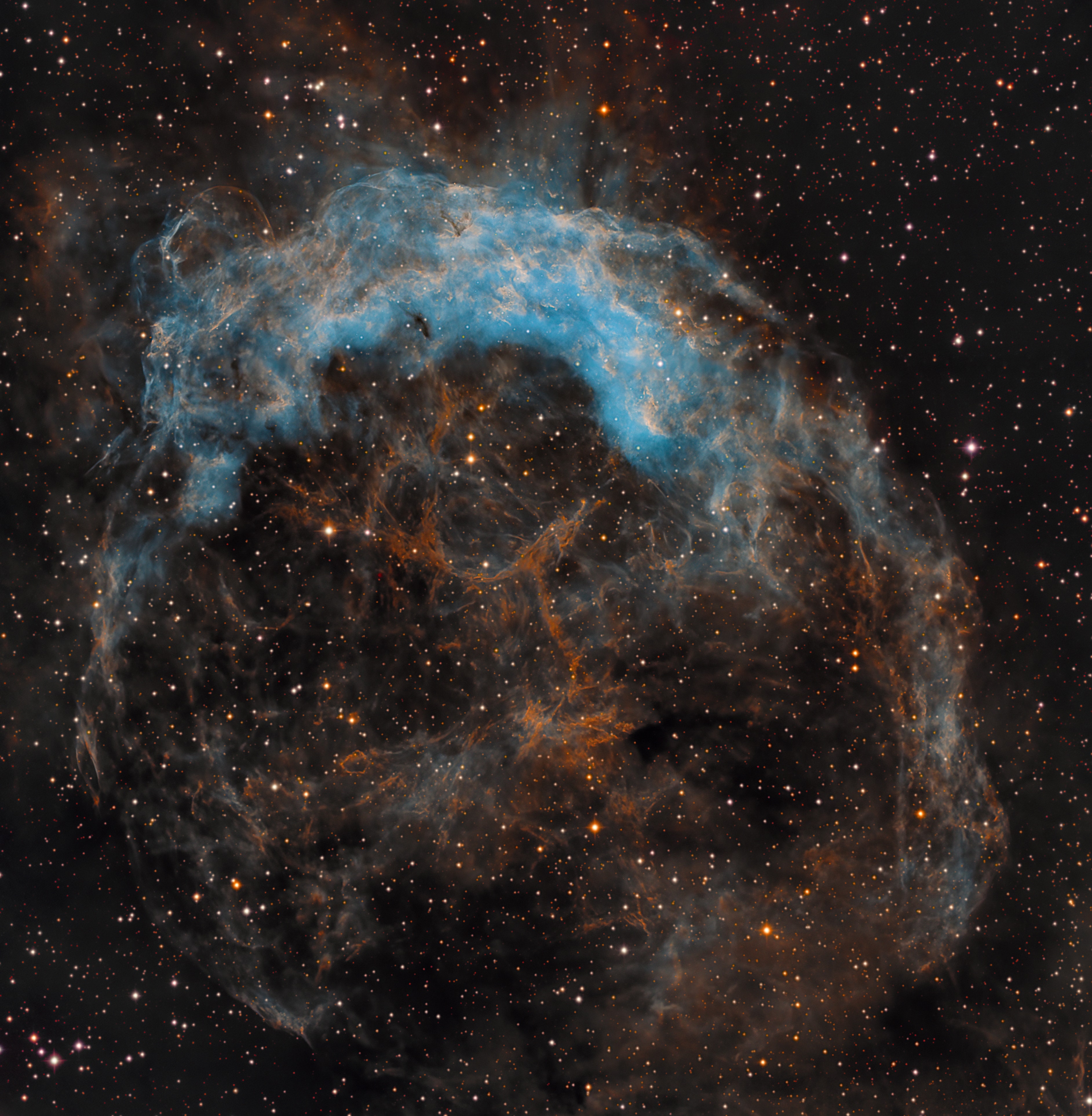 NGC 3199 lies about 12,000 light-years away, a glowing cosmic cloud in the nautical southern constellation of Carina. The nebula is about 75 light-years across in this narrowband, false-color view.  Though the deep image reveals a more or less complete bubble shape, it does look very lopsided with a much brighter edge along the top. Near the center is a Wolf-Rayet star, a massive, hot, short-lived star that generates an intense stellar wind. In fact, Wolf-Rayet stars are known to create nebulae with interesting shapes as their powerful winds sweep up surrounding interstellar material. In this case, the bright edge was thought to indicate a bow shock produced as the star plowed through a uniform medium, like a boat through water. But measurements have shown the star is not really moving directly toward the bright edge. So a more likely explanation is that the material surrounding the star is not uniform, but clumped and denser near the bright edge of windblown NGC 3199.