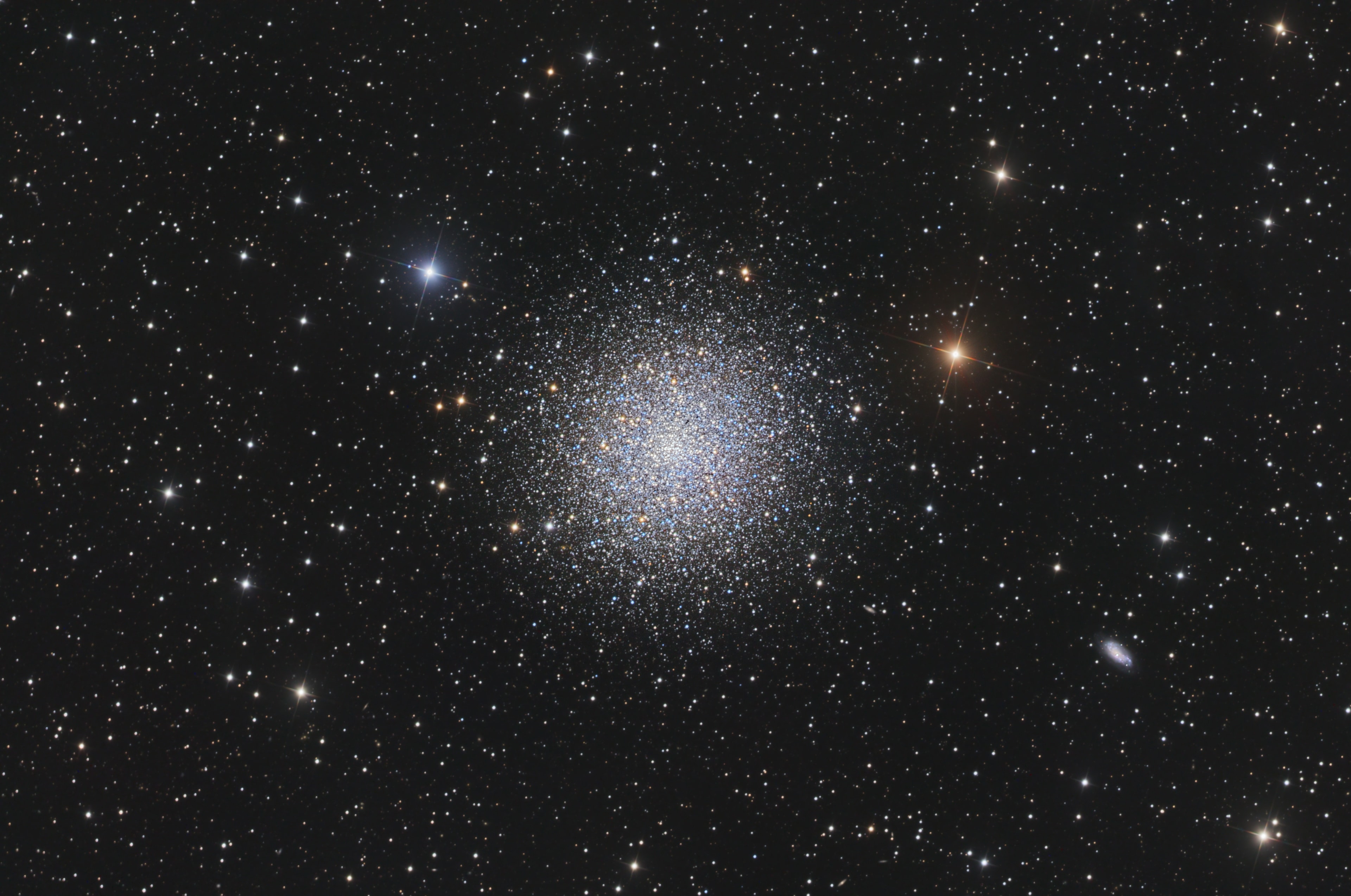 In 1716, English astronomer Edmond Halley noted, "This is but a little Patch, but it shews itself to the naked Eye, when the Sky is serene and the Moon absent." Of course, M13 is now less modestly recognized as the Great Globular Cluster in Hercules, one of the brightest globular star clusters in the northern sky. Sharp telescopic views like this one reveal the spectacular cluster's hundreds of thousands of stars. At a distance of 25,000 light-years, the cluster stars crowd into a region 150 light-years in diameter. Approaching the cluster core upwards of 100 stars could be contained in a cube just 3 light-years on a side. For comparison, the closest star to the Sun is over 4 light-years away. The remarkable range of brightness recorded in this image follows stars into the dense cluster core. Distant background galaxies in the medium-wide field of view include NGC 6207 at the lower right.