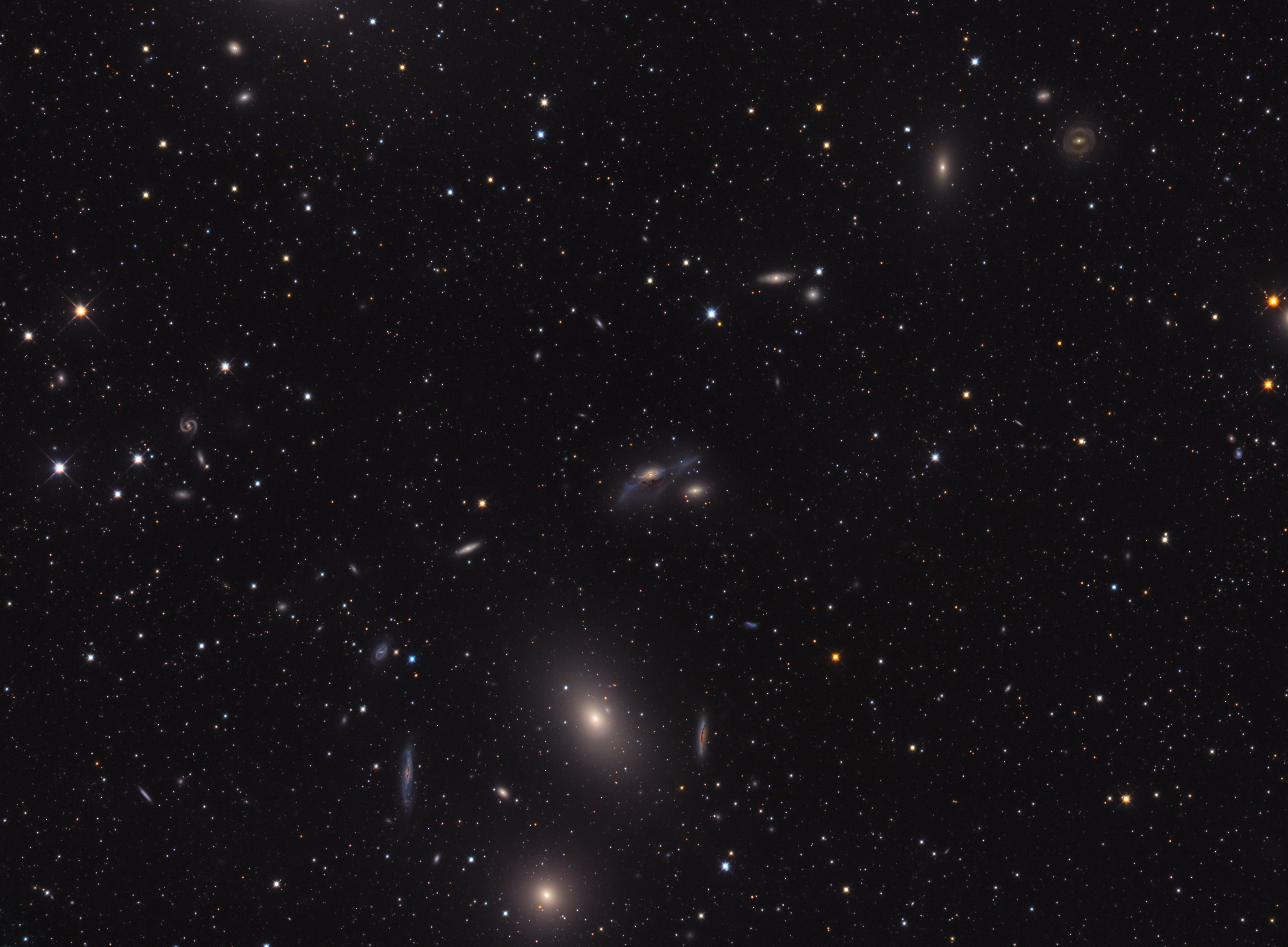 Near the heart of the Virgo Galaxy Cluster the string of galaxies known as Markarian's Chain stretches across this deep telescopic field of view. Anchored in the frame at bottom center by prominent lenticular galaxies, M84 (bottom) and M86, you can follow the chain up and to the right. Near center you'll spot the pair of interacting galaxies NGC 4438 and NGC 4435, known to some as Markarian's Eyes. Its center an estimated 50 million light-years distant, the Virgo Cluster itself is the nearest galaxy cluster. With up to about 2,000 member galaxies, it has a noticeable gravitational influence on our own Local Group of Galaxies. Within the Virgo Cluster at least seven galaxies in Markarian's Chain  appear to move coherently, although others may appear to be part of the chain by chance.