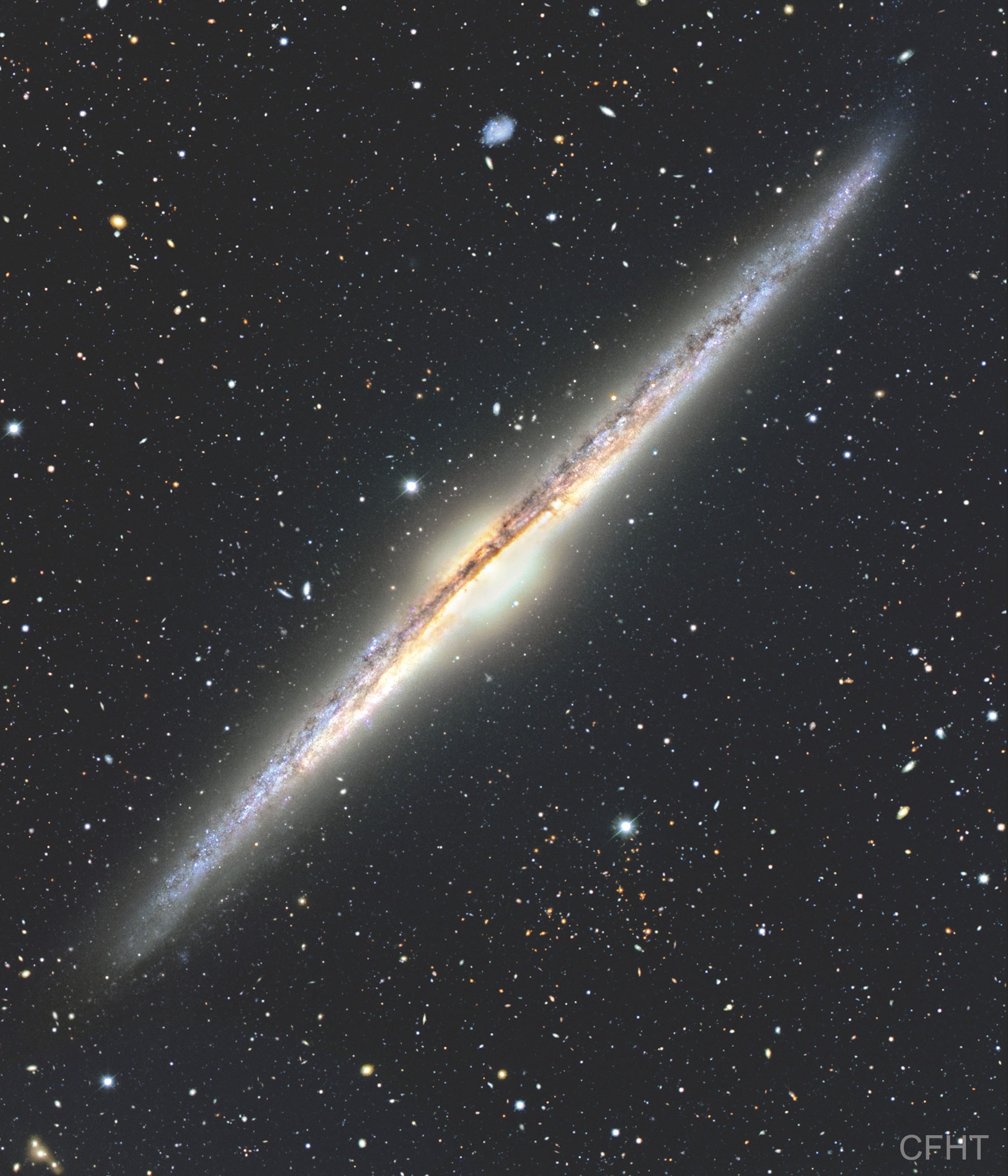 Is our Milky Way Galaxy this thin?  Magnificent spiral galaxy NGC 4565 is viewed edge-on from planet Earth. Also known as the Needle Galaxy for its narrow profile, bright NGC 4565 is a stop on many telescopic tours of the northern sky, in the faint but well-groomed constellation Coma Berenices. This sharp, colorful image reveals the spiral galaxy's boxy, bulging central core cut by obscuring dust lanes that lace NGC 4565's thin galactic plane. An assortment of other background galaxies is included in the pretty field of view. Thought similar in shape to our own Milky Way Galaxy, NGC 4565 lies about 40 million light-years distant and spans some 100,000 light-years.  Easily spotted with small telescopes, sky enthusiasts consider NGC 4565 to be a prominent celestial masterpiece Messier missed.